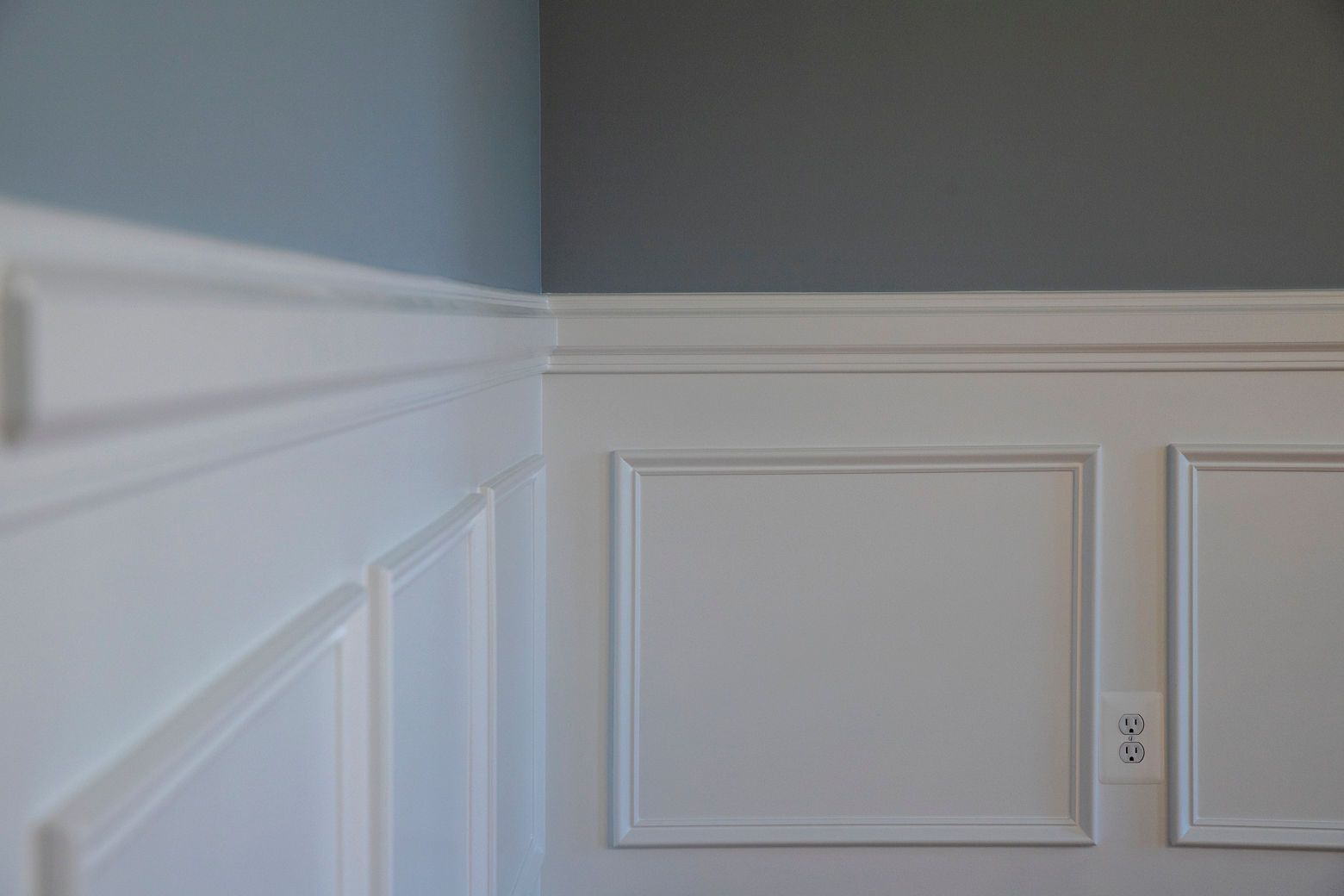 Detailed wainscoting paneling as a feature wall in a modern home.