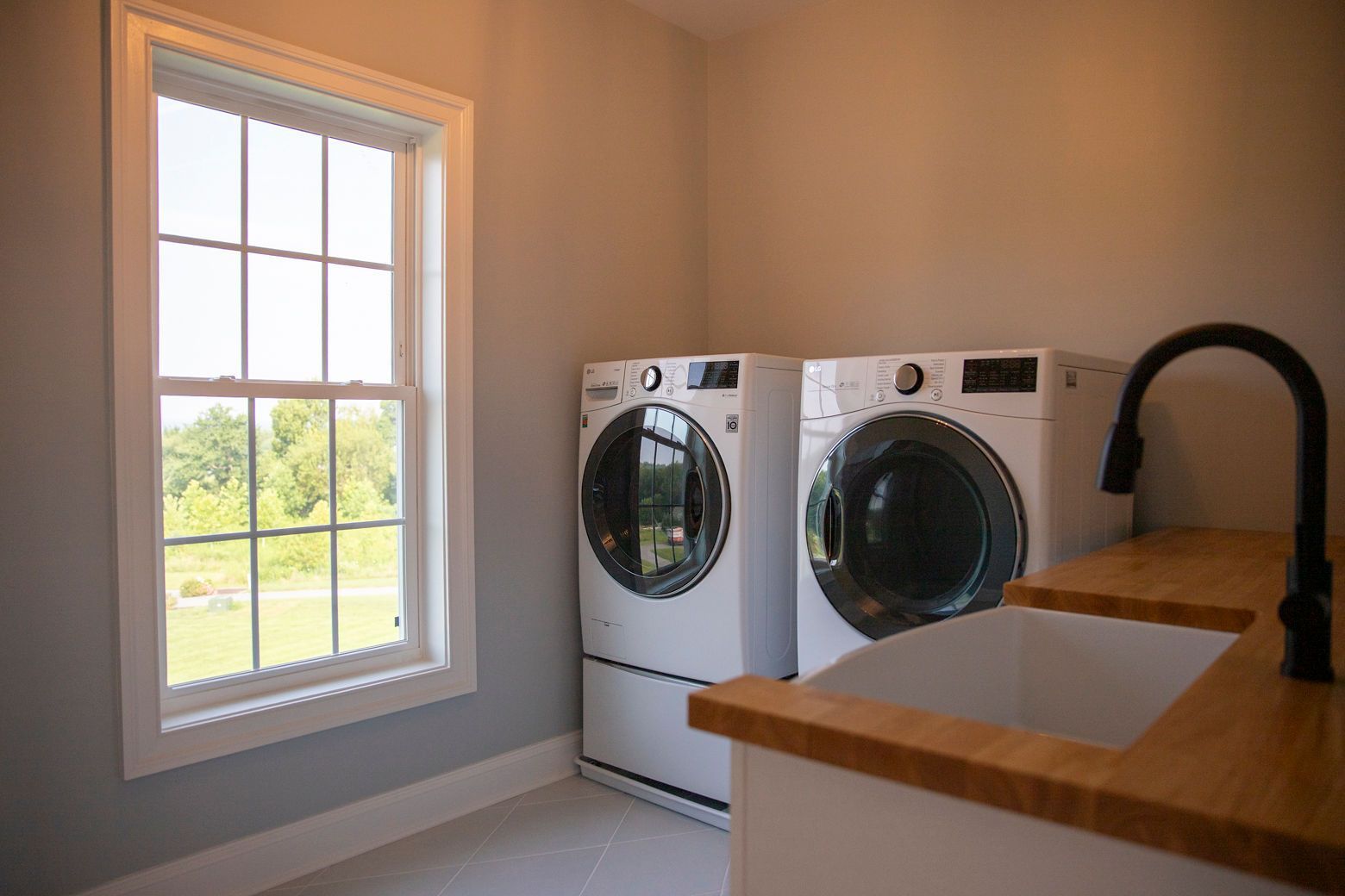We transformed this laundry room with new flooring, a wood countertop, and a modern washer and dryer.
