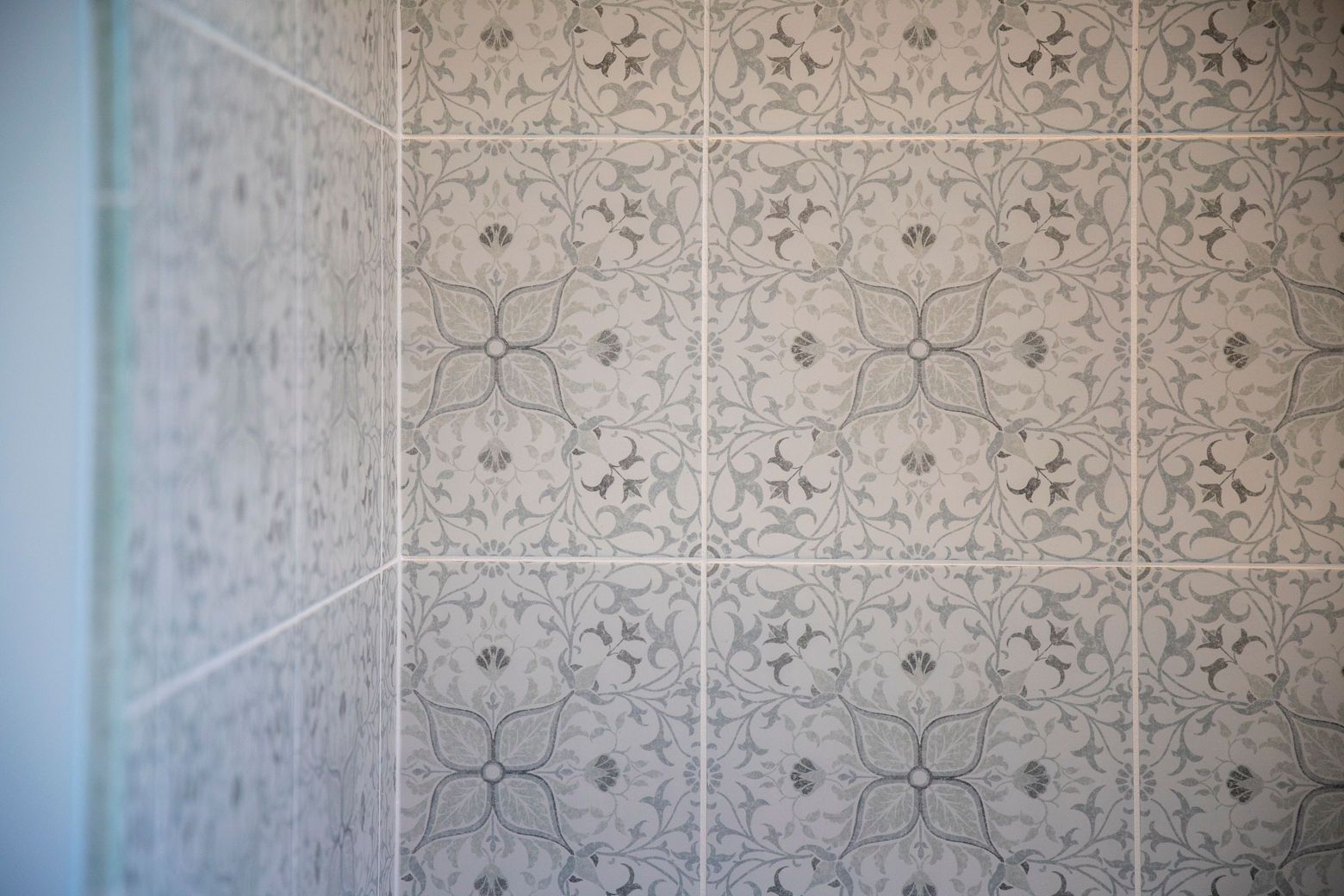 Close-up of a new white bathtub and a decorative tile installation in a Westminster hall bathroom.