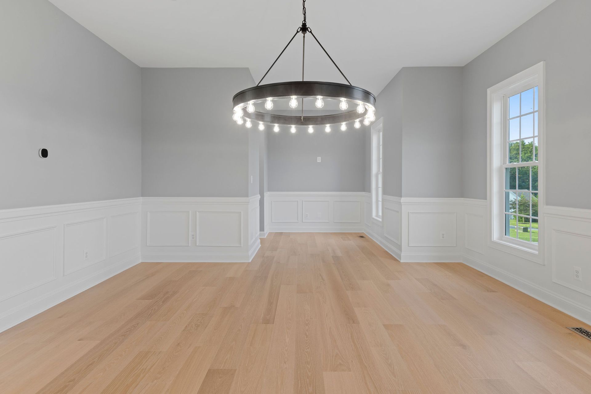 A renovated dining room with new wainscoting and hardwood floors.
