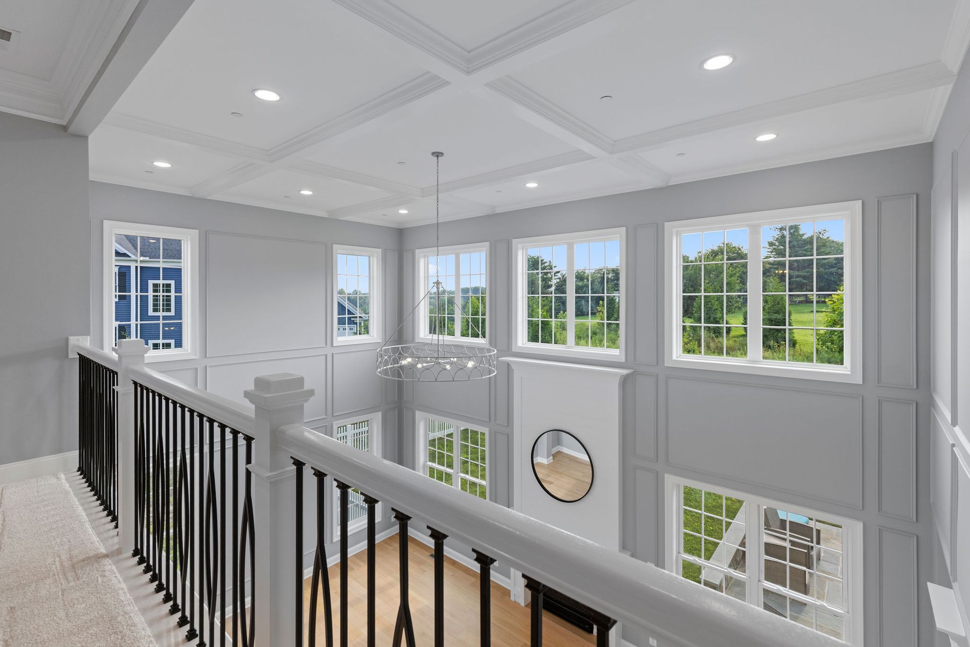 A newly renovated living room with a fireplace, elegant wainscoting, and new hardwood flooring.