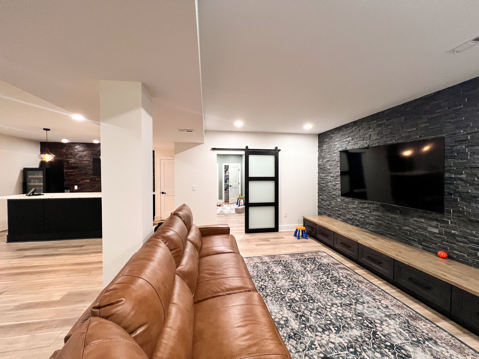 Beautiful finished basement with black accent wall and entertainment center.