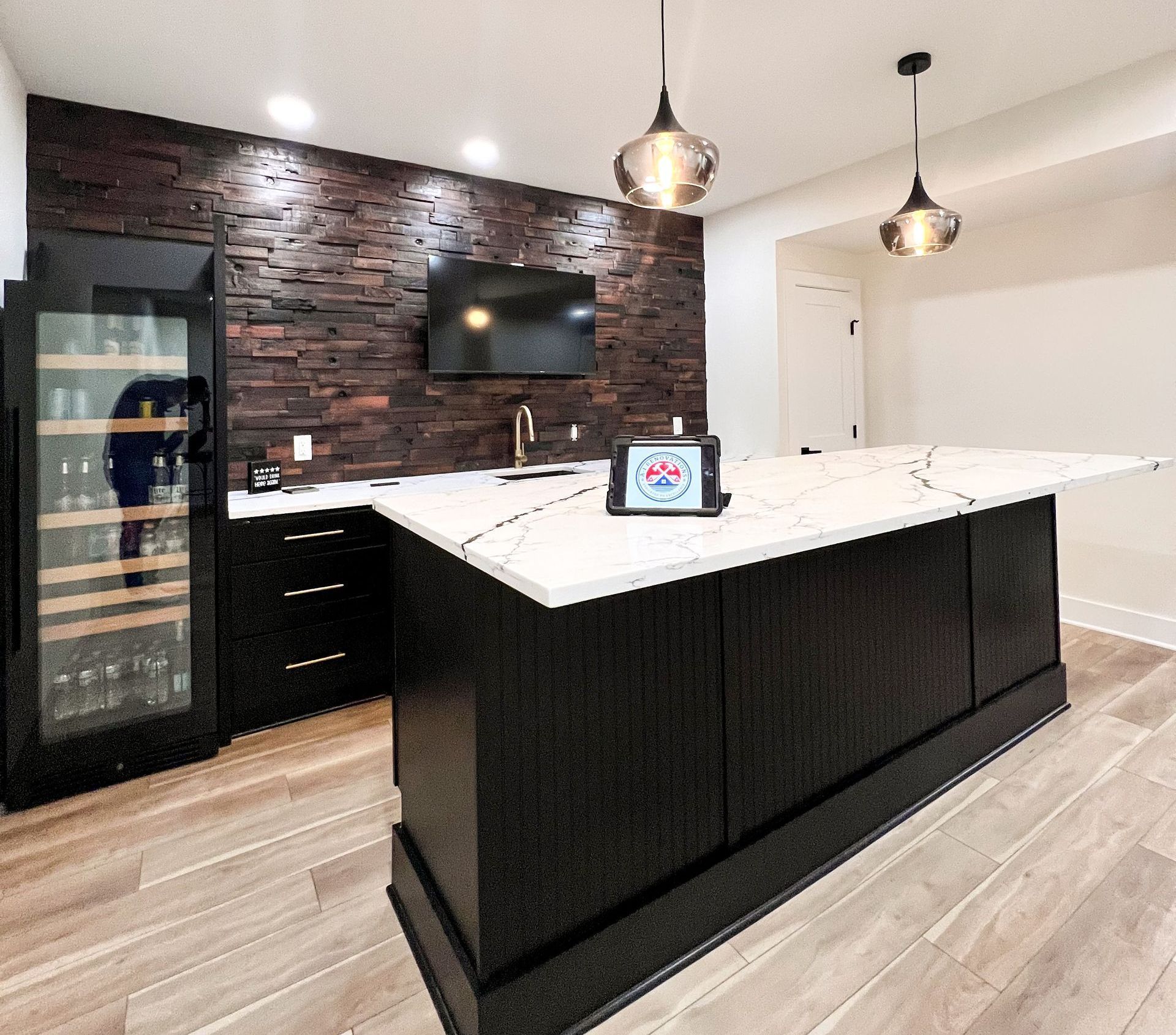 Finished basement bar area with dark wood backsplash, white countertop, and island seating.