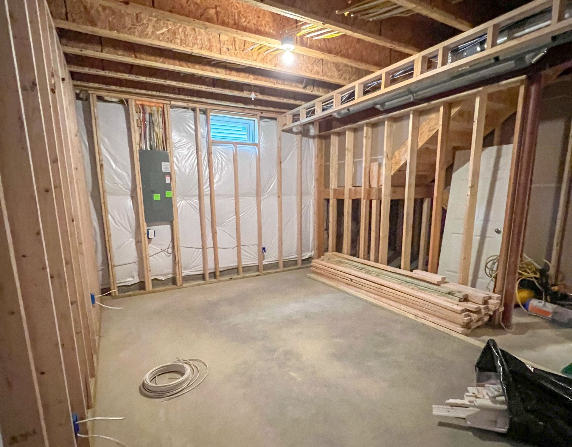 Unfinished basement in Owings Mills, MD. Exposed framing, concrete floor, and visible ceiling joists.