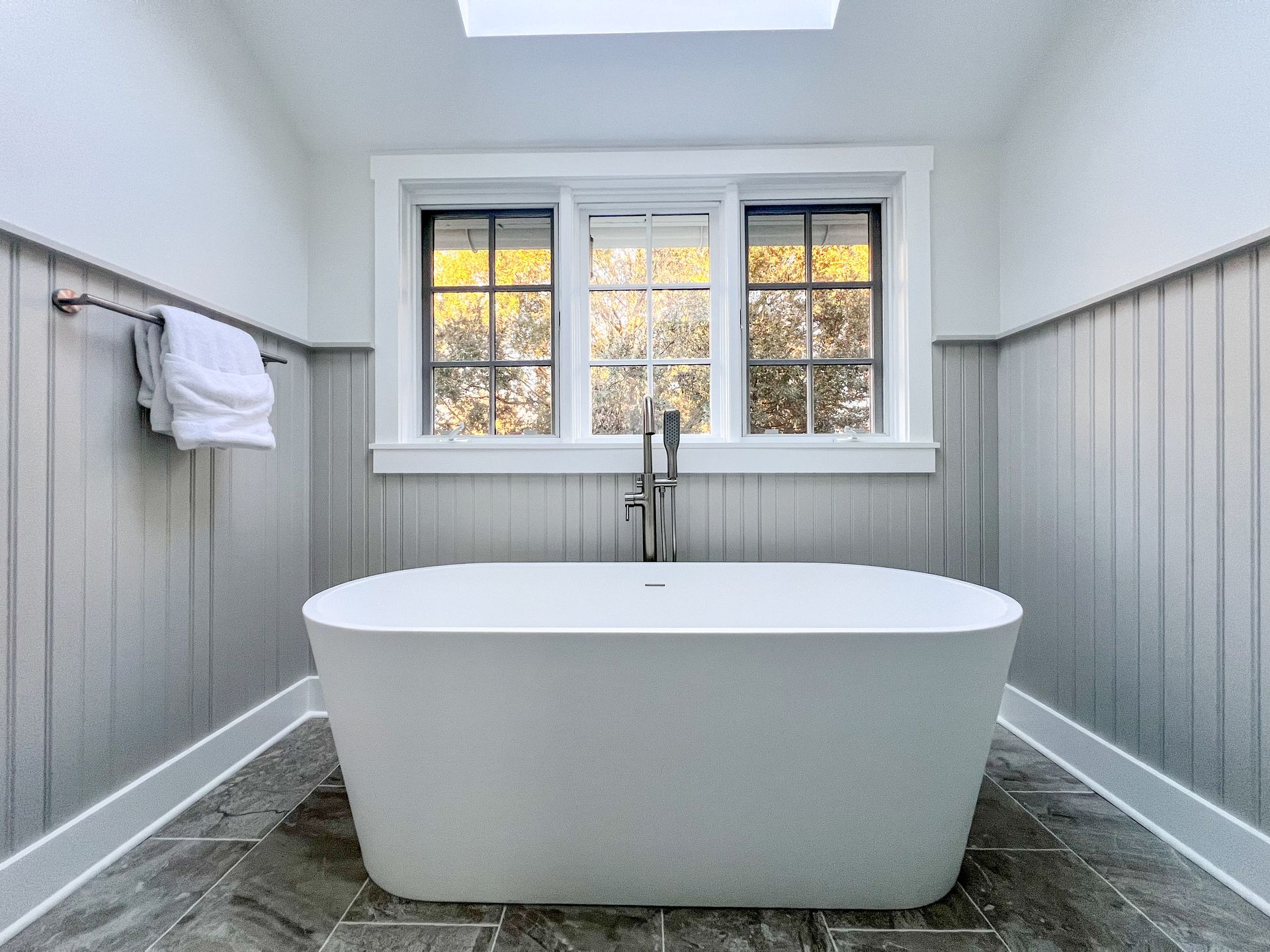 Freestanding tub under a window in an Owings Mills bathroom.