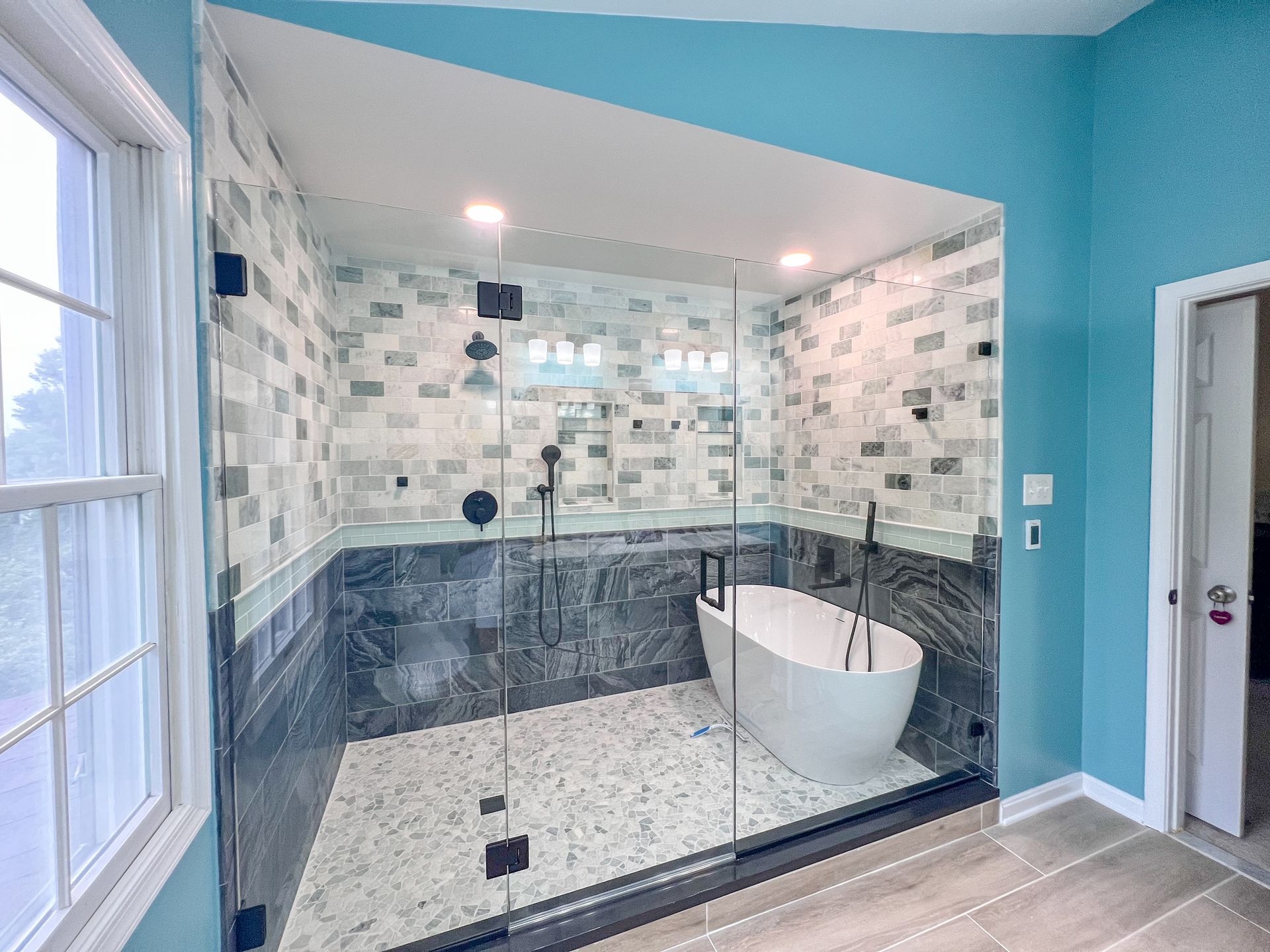 Contemporary bathroom remodel featuring a freestanding jacuzzi tub and neutral