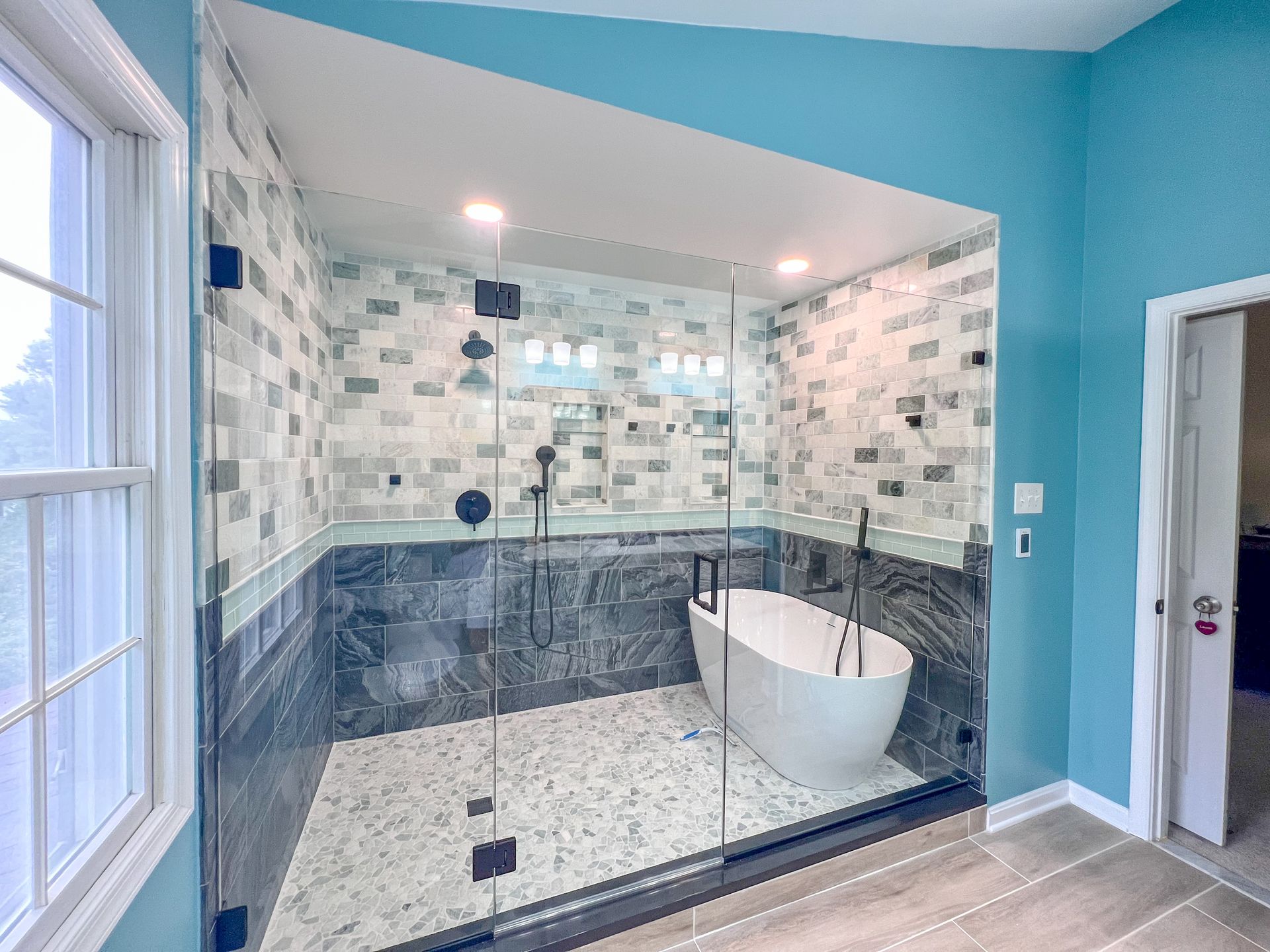 Modern bathroom renovation in Ellicott City, MD, featuring a freestanding tub, glass shower.