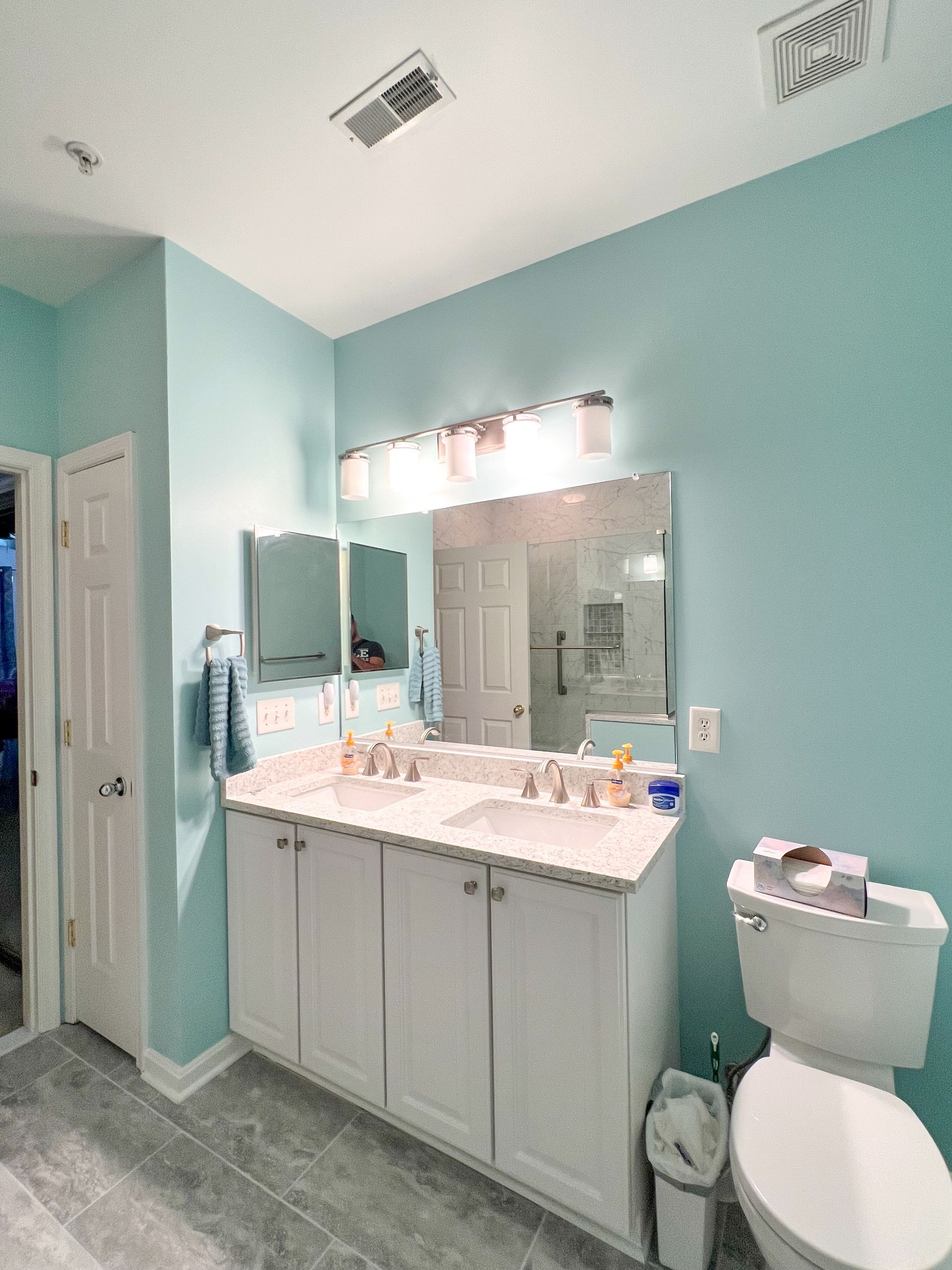 Double sink vanity with white countertop in a bathroom remodel.