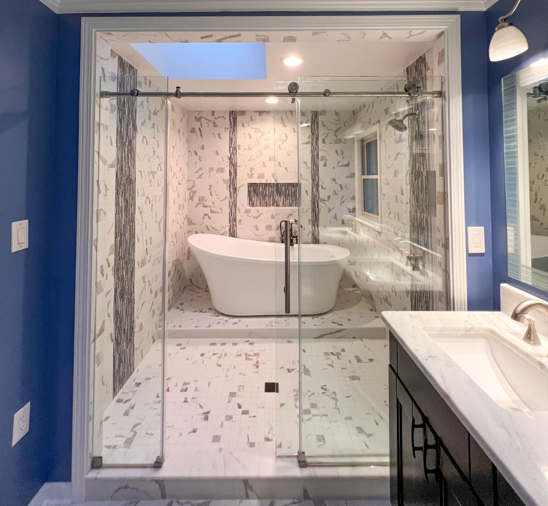 Luxury modern bathroom in Maryland with a freestanding jacuzzi tub and rainfall shower.