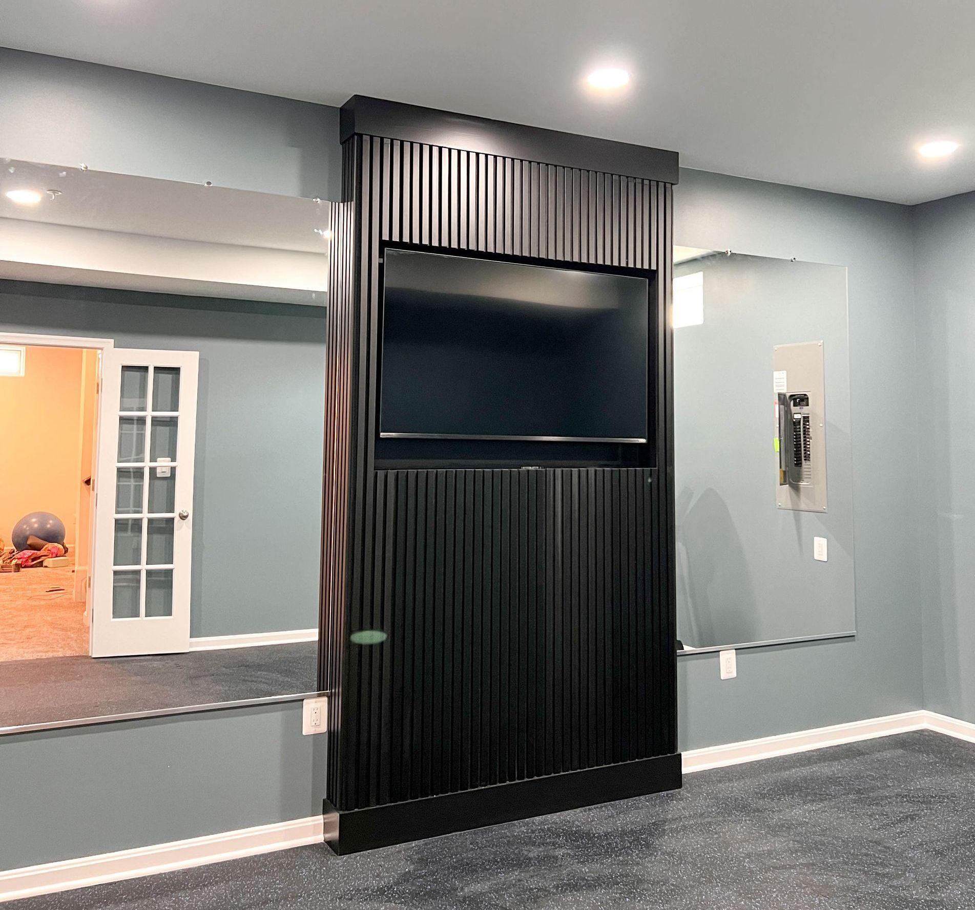  Finished black slat media wall in Owings Mills home gym.