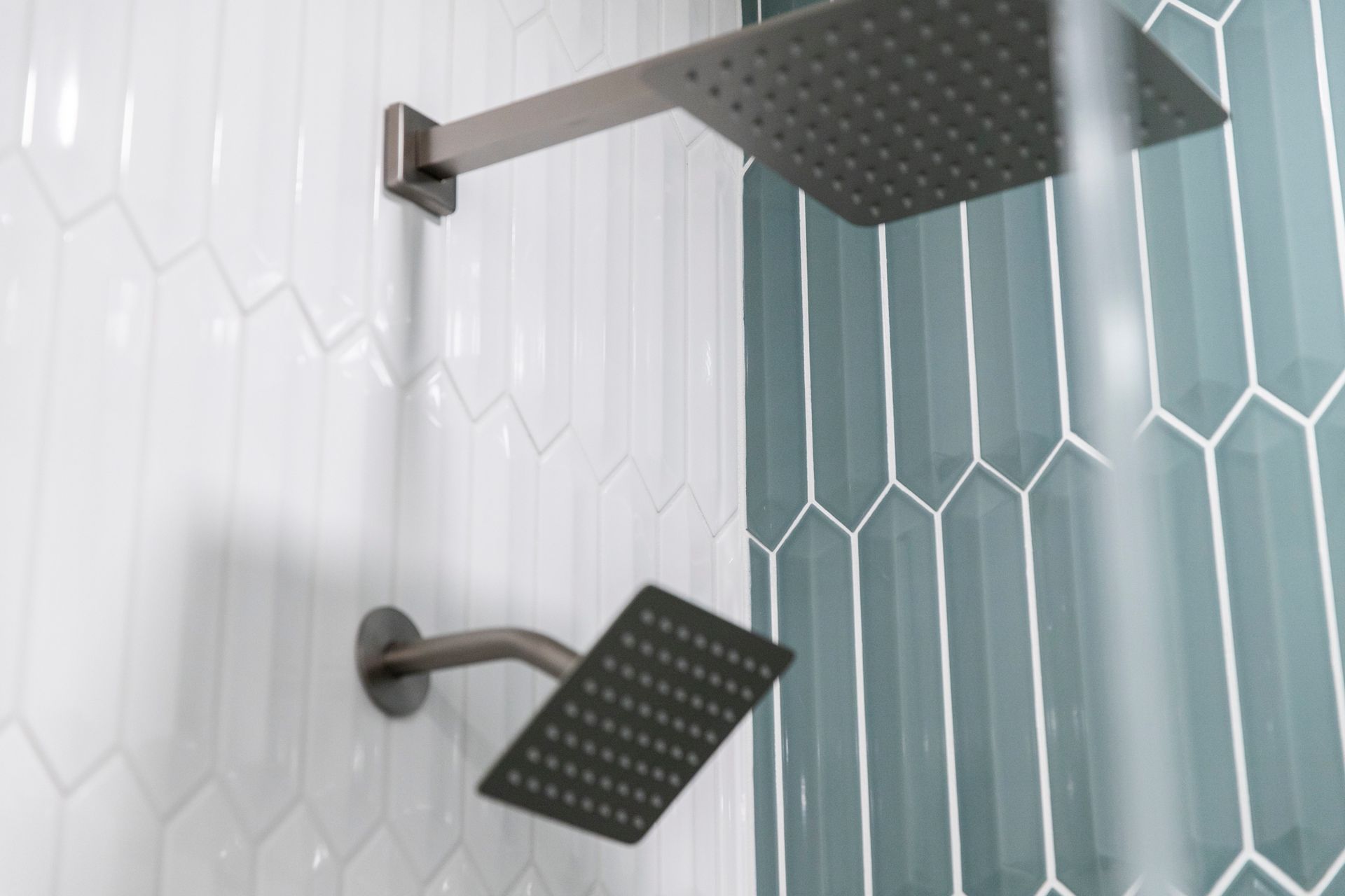 Dual-head shower system in a modern Cockeysville bathroom, with two rain shower heads and striking tile work.