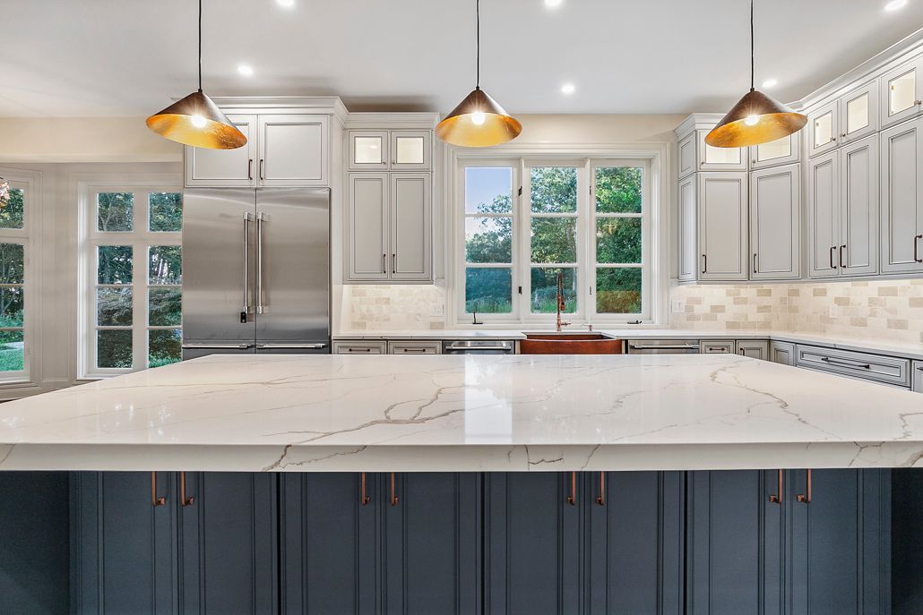 A side view of the navy blue kitchen island with modern copper hardware and built-in storage.