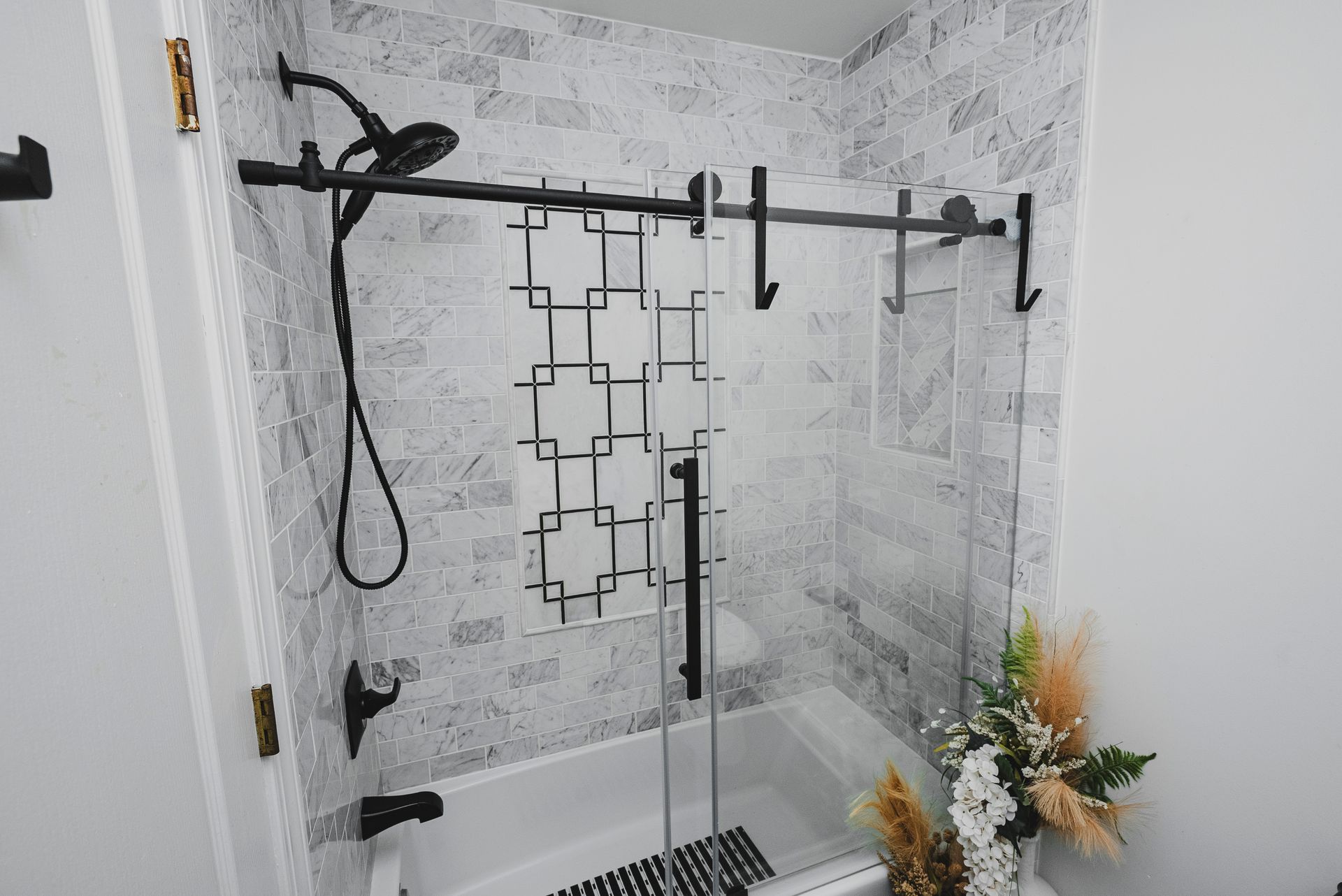 Finished hallway bathroom featuring a modern alcove bathtub with a sliding glass door.