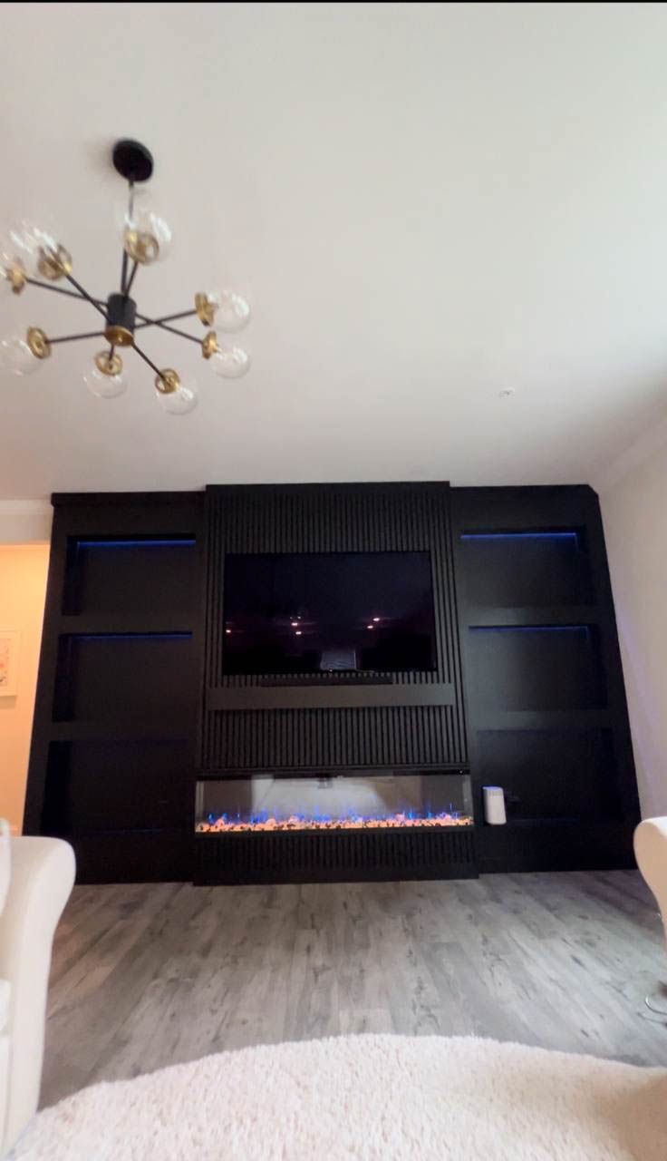 Modern black fireplace and media wall in living room. Features vertical slats