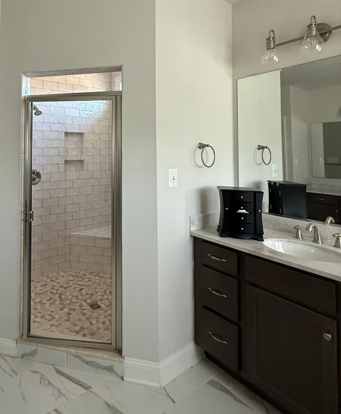 See the bathroom transformation from a dated tub and vanities to a new, modern, and bright space.