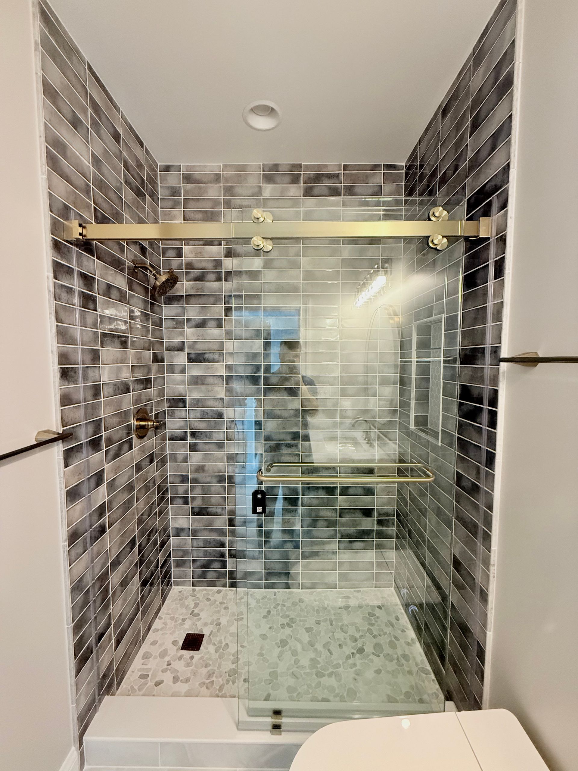 Shower detail highlighting the decorative tile and a stylish faucet.