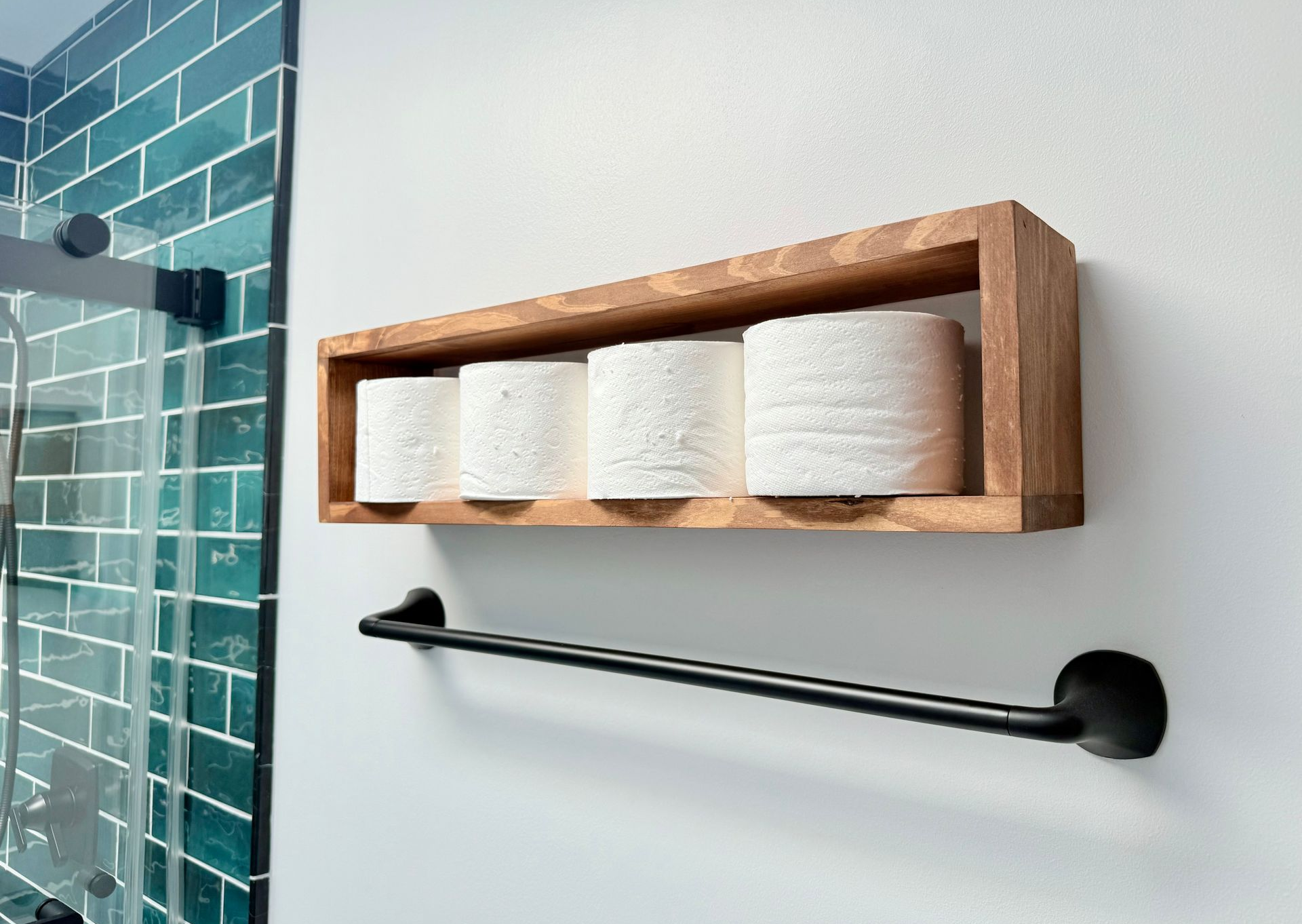 Custom wooden shelf and matte black towel bar in a newly remodeled bathroom.
