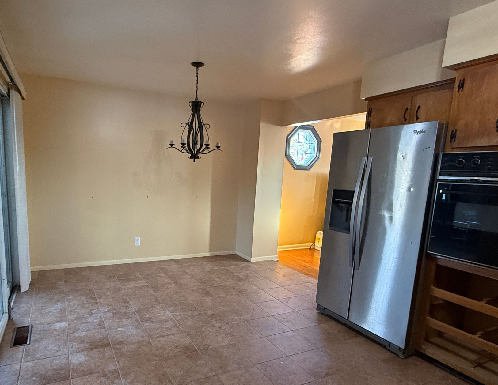 View of the initial kitchen area with underutilized wall space and dated flooring before the modern upgrade.