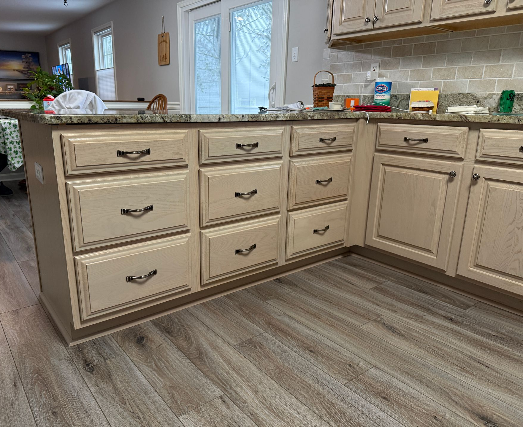 A view of the outdated cabinetry and backsplash before the professional spray finishing and quartz installation.