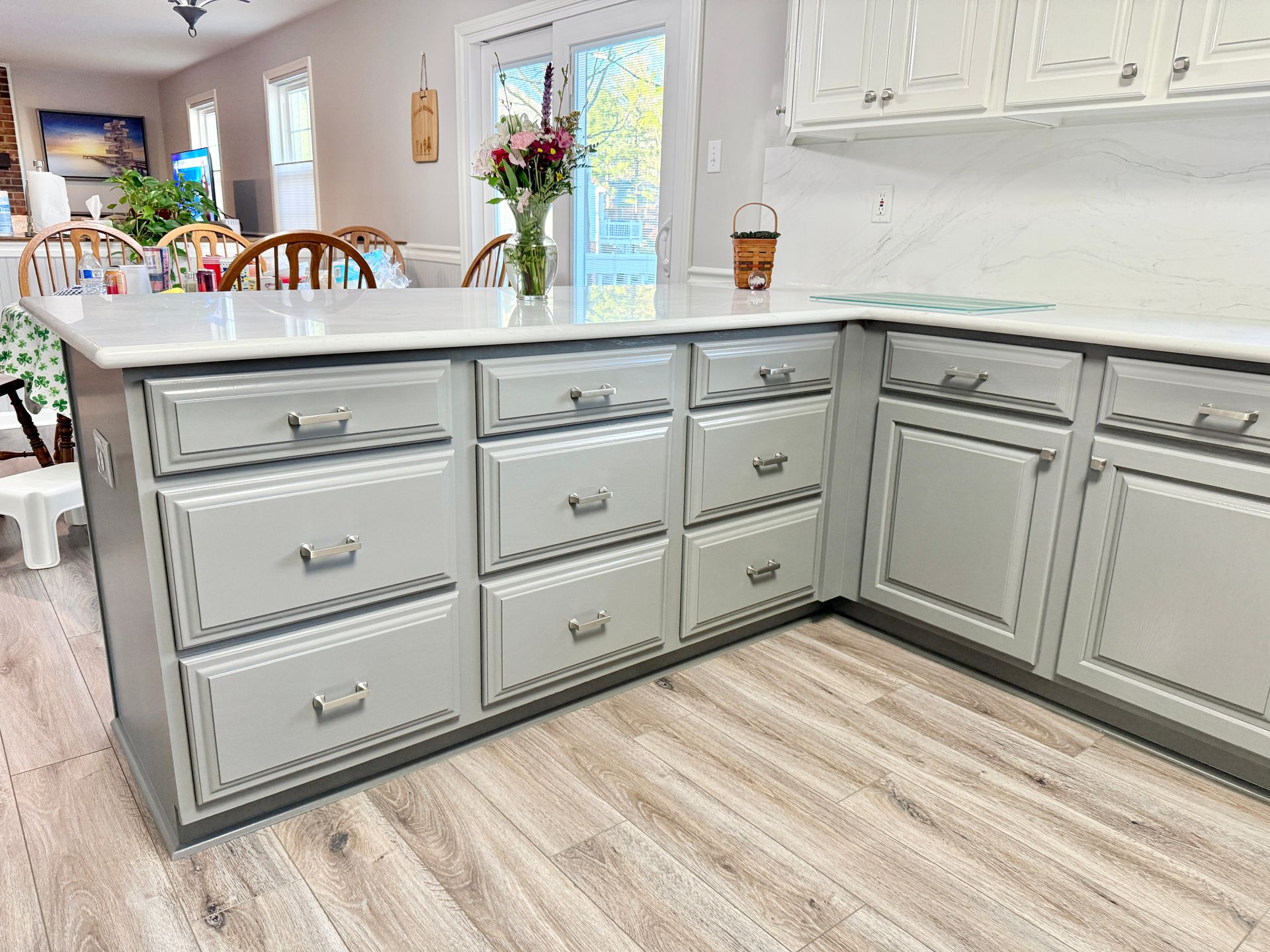 A post-renovation view showing the ultra-smooth cabinet surfaces and integrated stone backsplash.