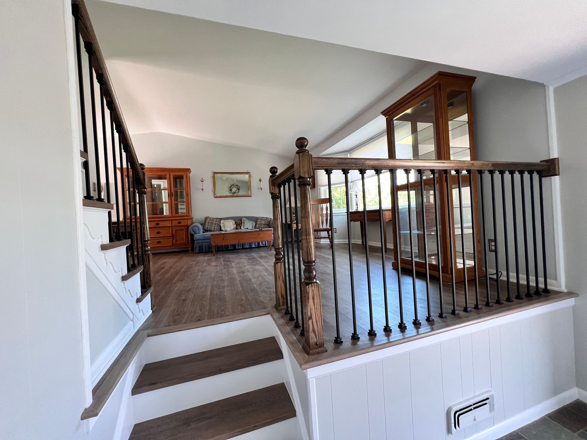 Professional staircase trim work showing clean white stringers and decorative brackets on a Maryland home remodel.