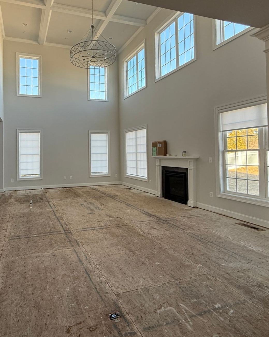 Before & After: A living room renovation with a fireplace, new hardwood flooring, and stylish wainscoting.