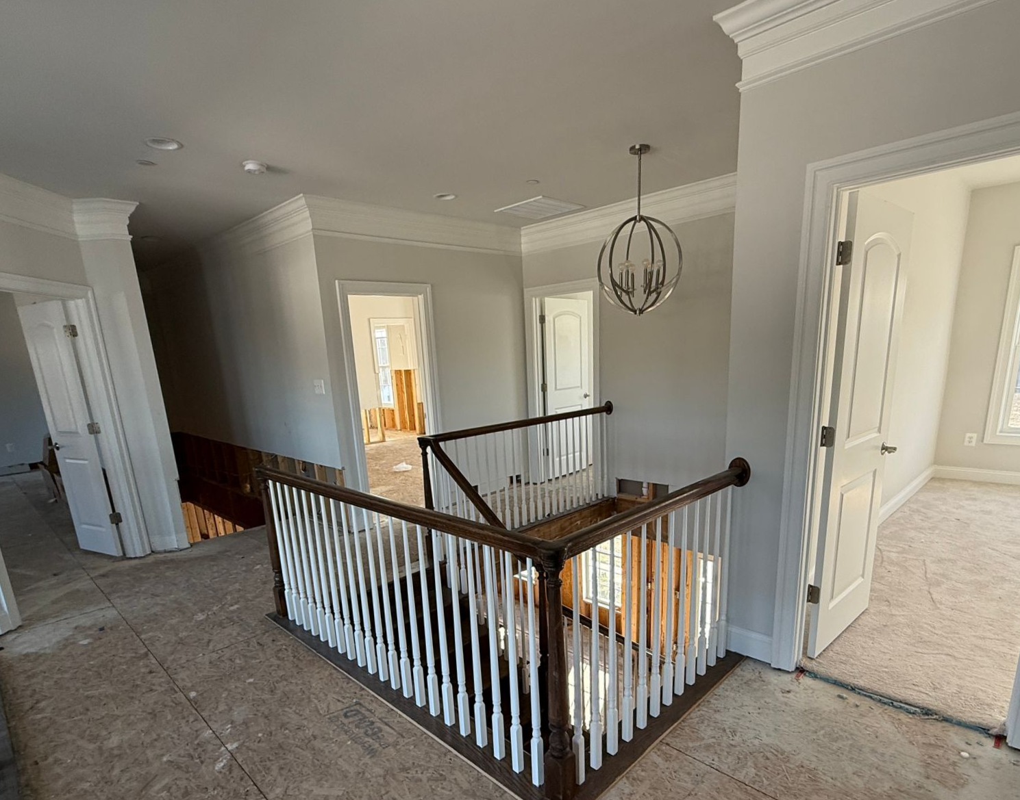 Unfinished staircase during a home renovation, with exposed wood framing and subflooring.