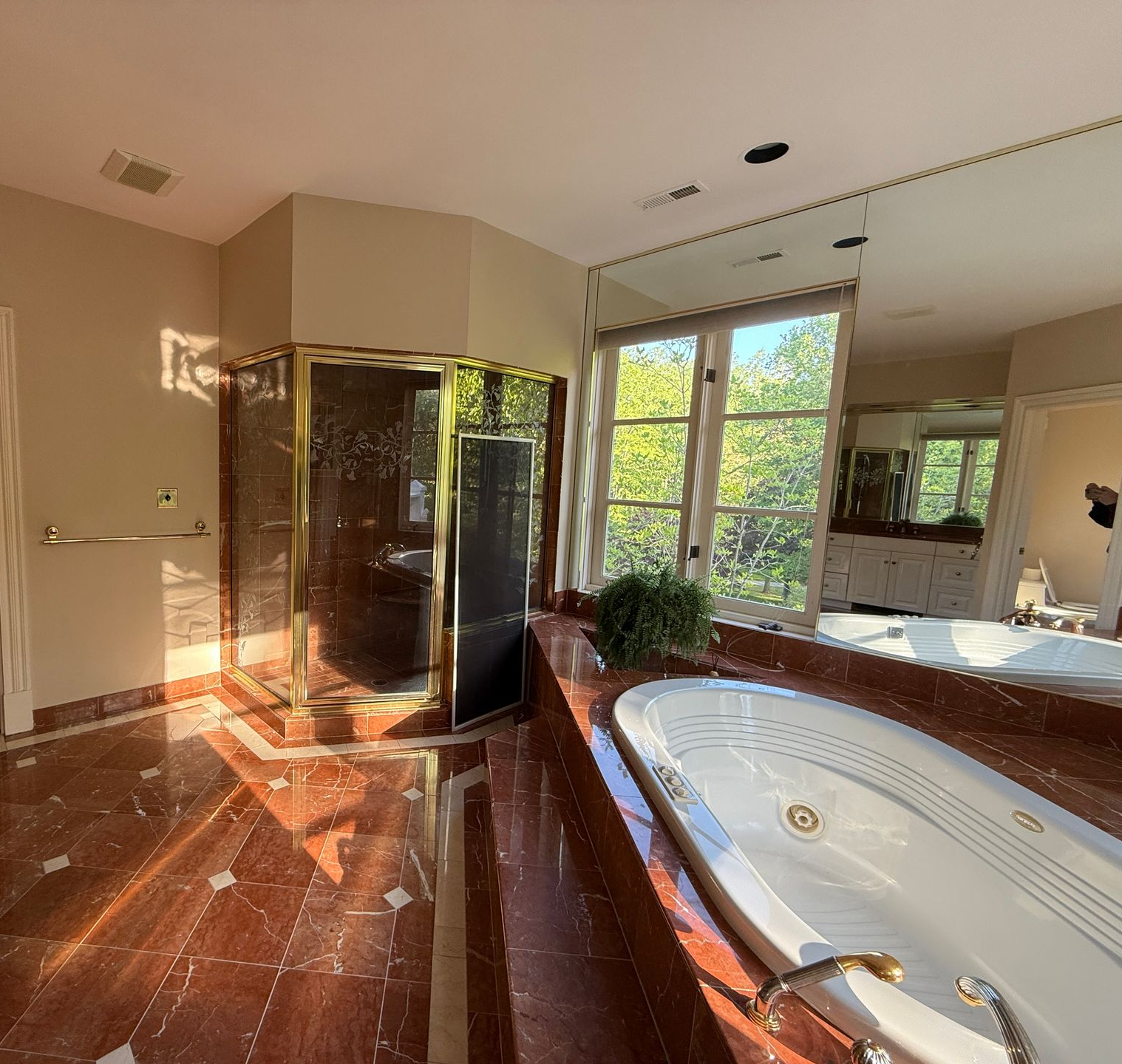 Original layout of a Cockeysville bathroom before remodeling, featuring a large corner tub and outdated shower, with a doorway leading to the old toilet area.