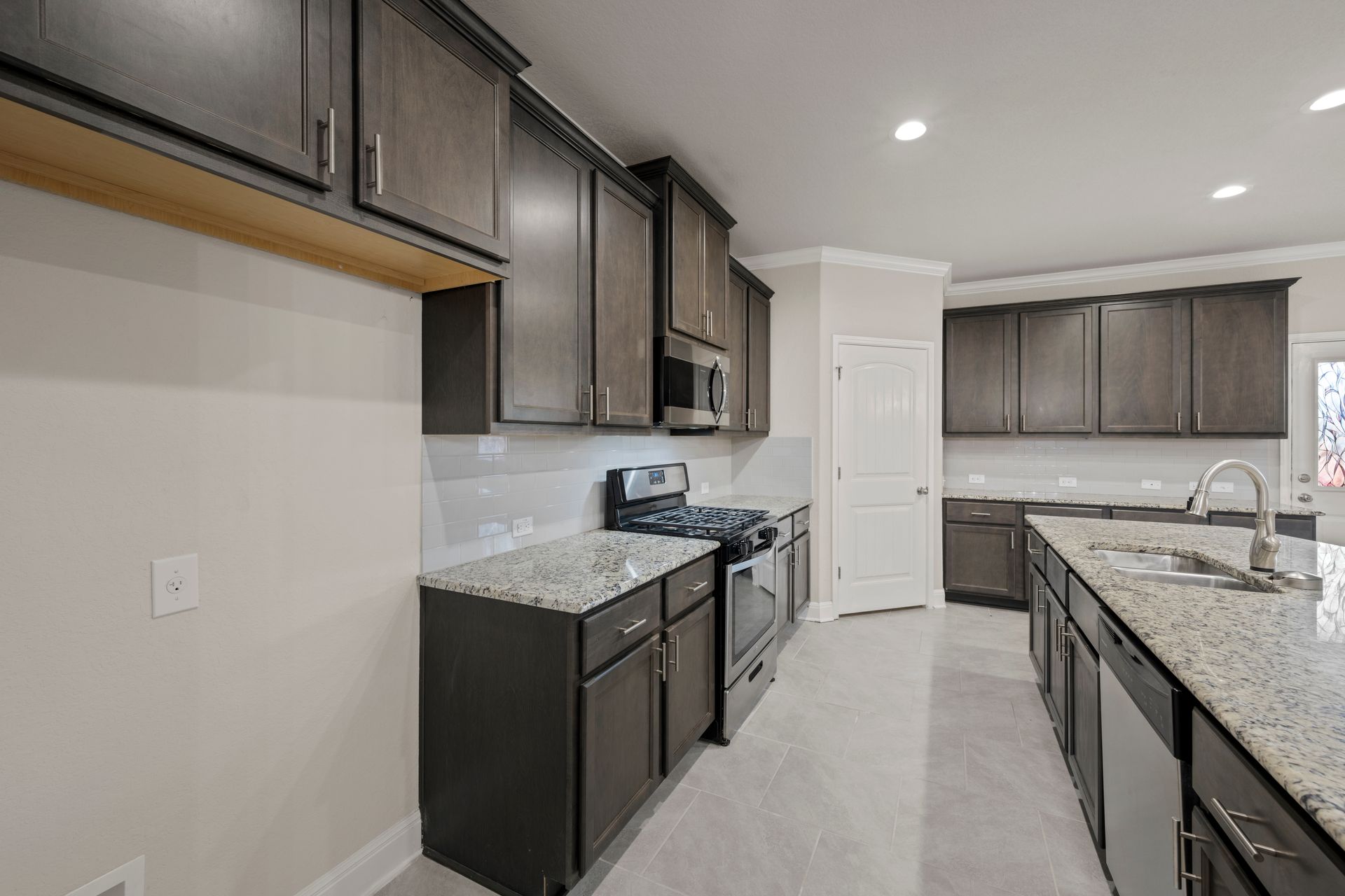 Elegant dark cabinet kitchen in Columbia, Maryland, showcasing a traditional design with modern touches, granite counters, and a large island.