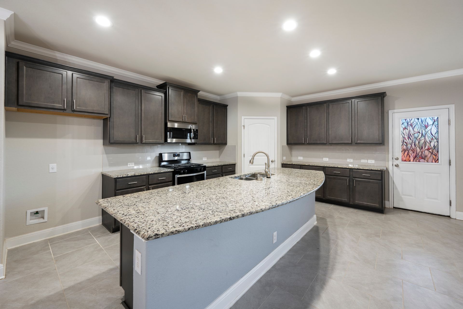 Open concept dark cabinet kitchen in a finished basement in Columbia, MD.