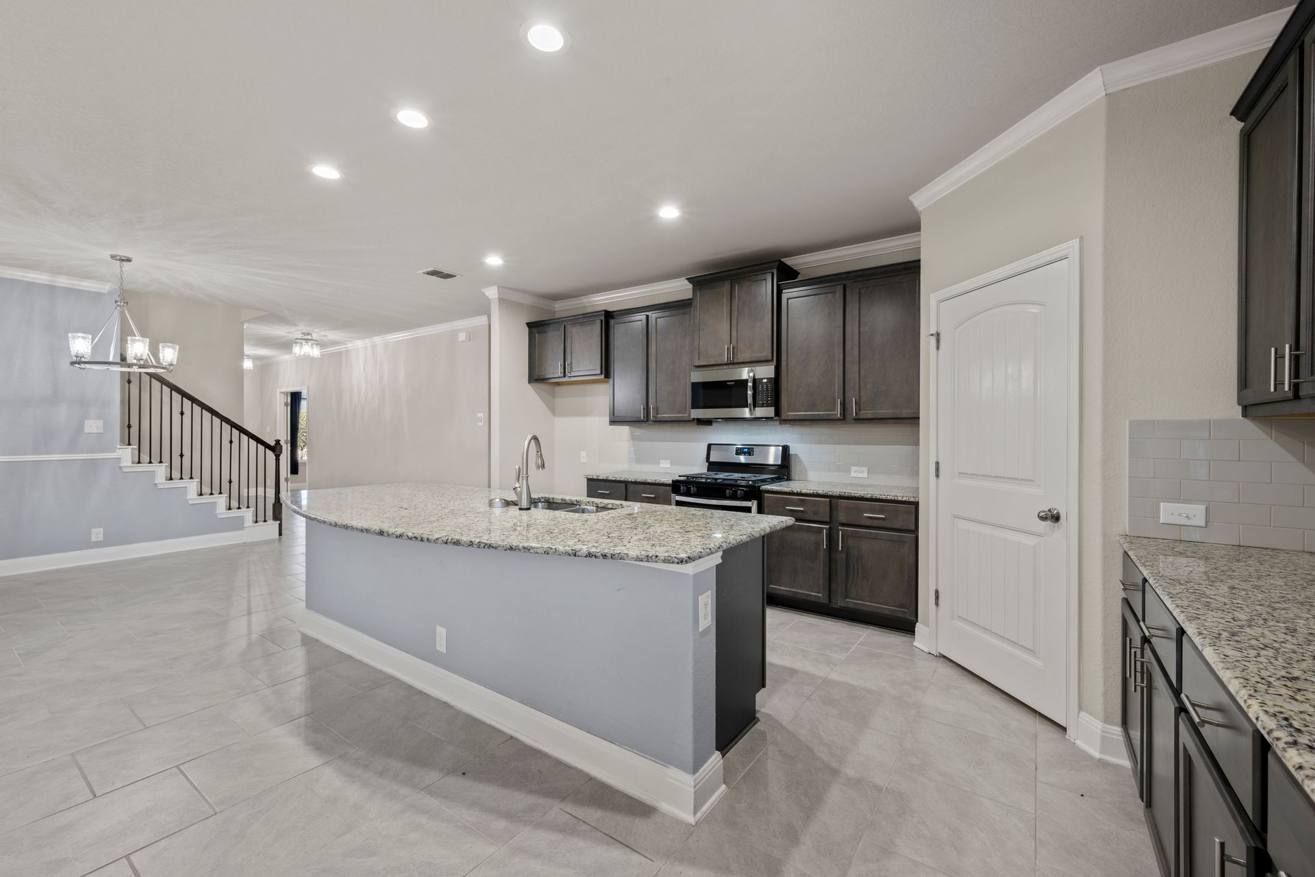 Dark cabinet kitchen remodel in Columbia, Maryland, featuring shaker-style cabinets, granite countertops, a large island, and stainless steel appliances.