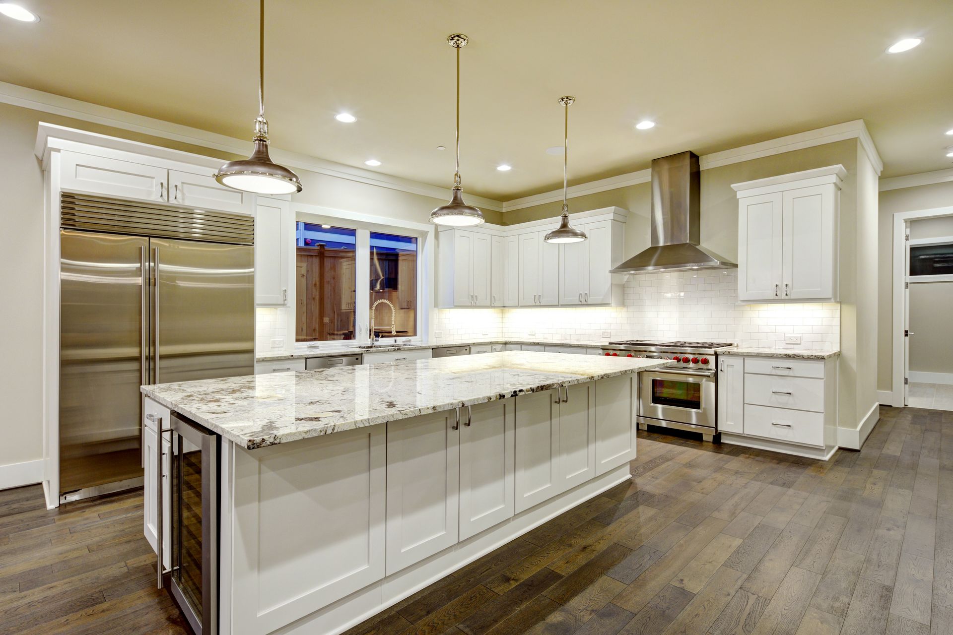 Modern white kitchen remodel in Timoniu, Maryland, featuring white shaker cabinets, a large granite 