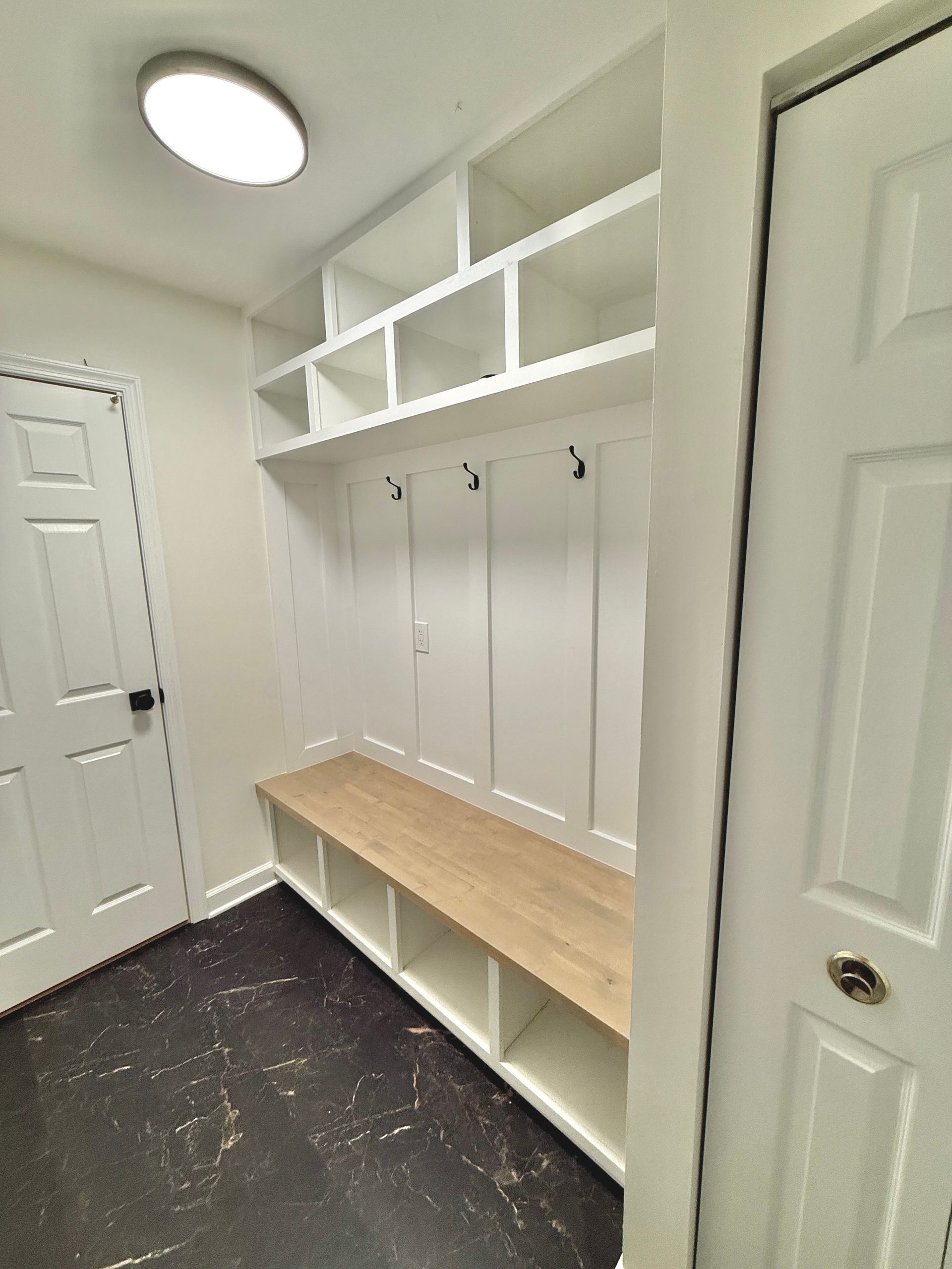 Custom mudroom unit featuring storage cubbies, organizer shelves, and a wood bench.