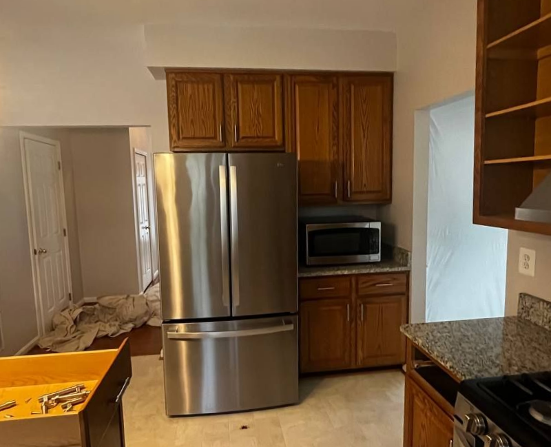 Original cramped kitchen layout with vinyl sheet flooring and a traditional small island before renovation.