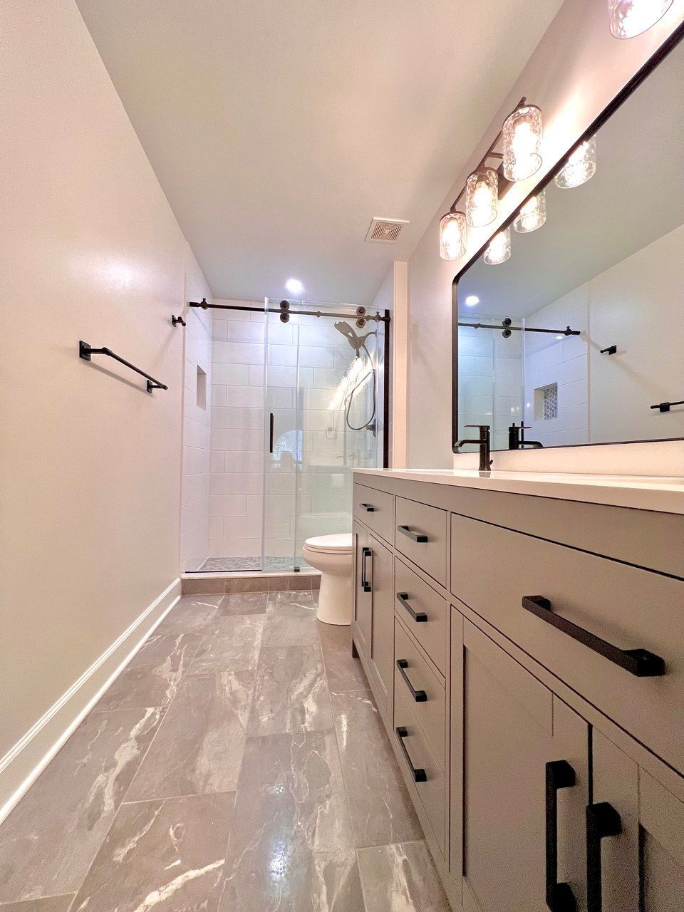 Spacious bathroom renovation featuring updated vanity, sink, and lighting in Westminster, MD.