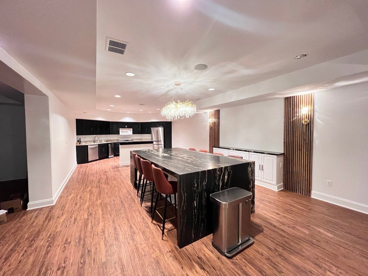 Finished basement with large kitchen island, guitars on wall, and TV in Westminster, MD