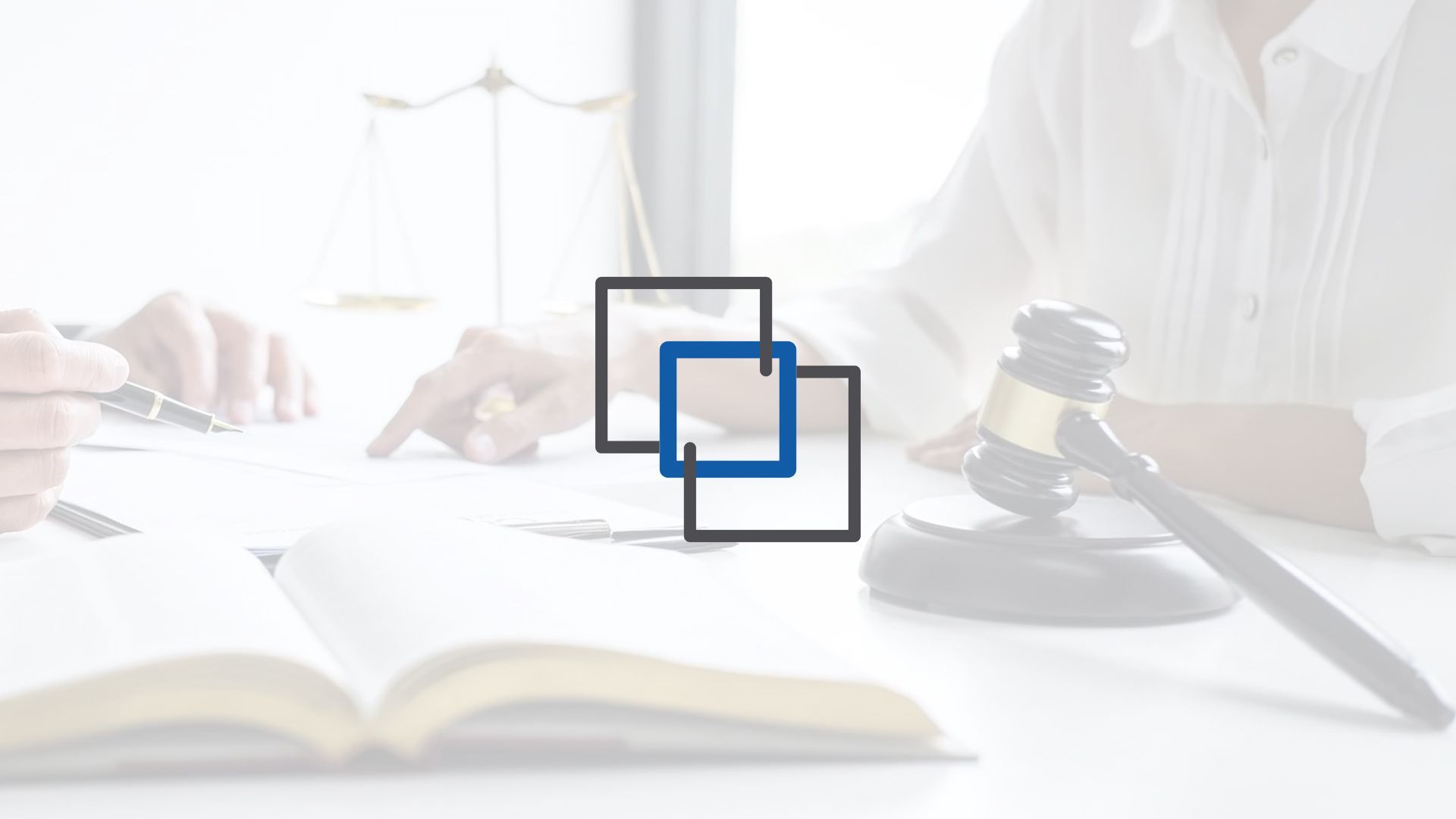 A person is sitting at a table with a book and a judge 's gavel.