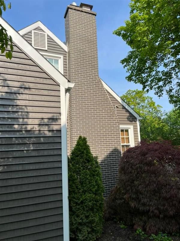 Fireplace with tiled surround, mantle, and wall above, flanked by windows.