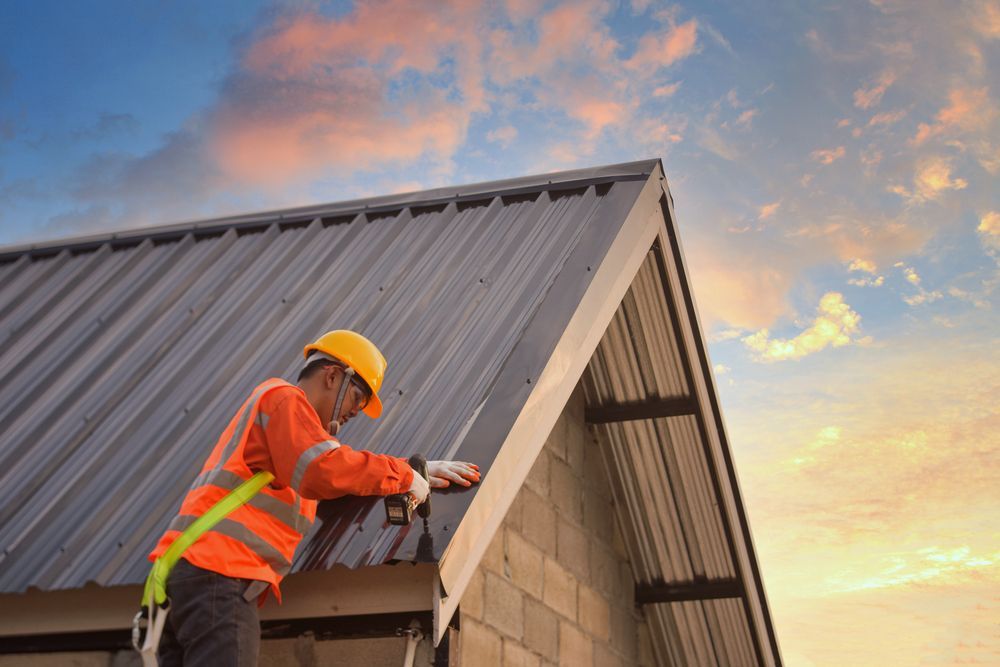 A construction worker is working on the roof of a building.