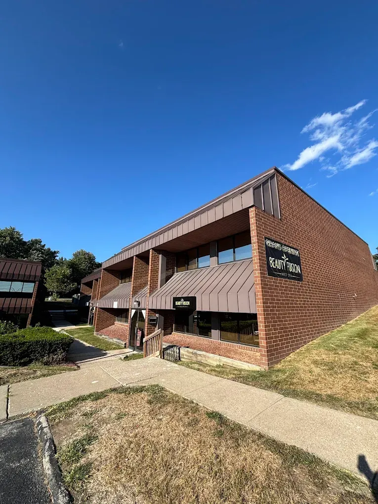 Brick building with brown accents and Black Market sign under a blue sky.