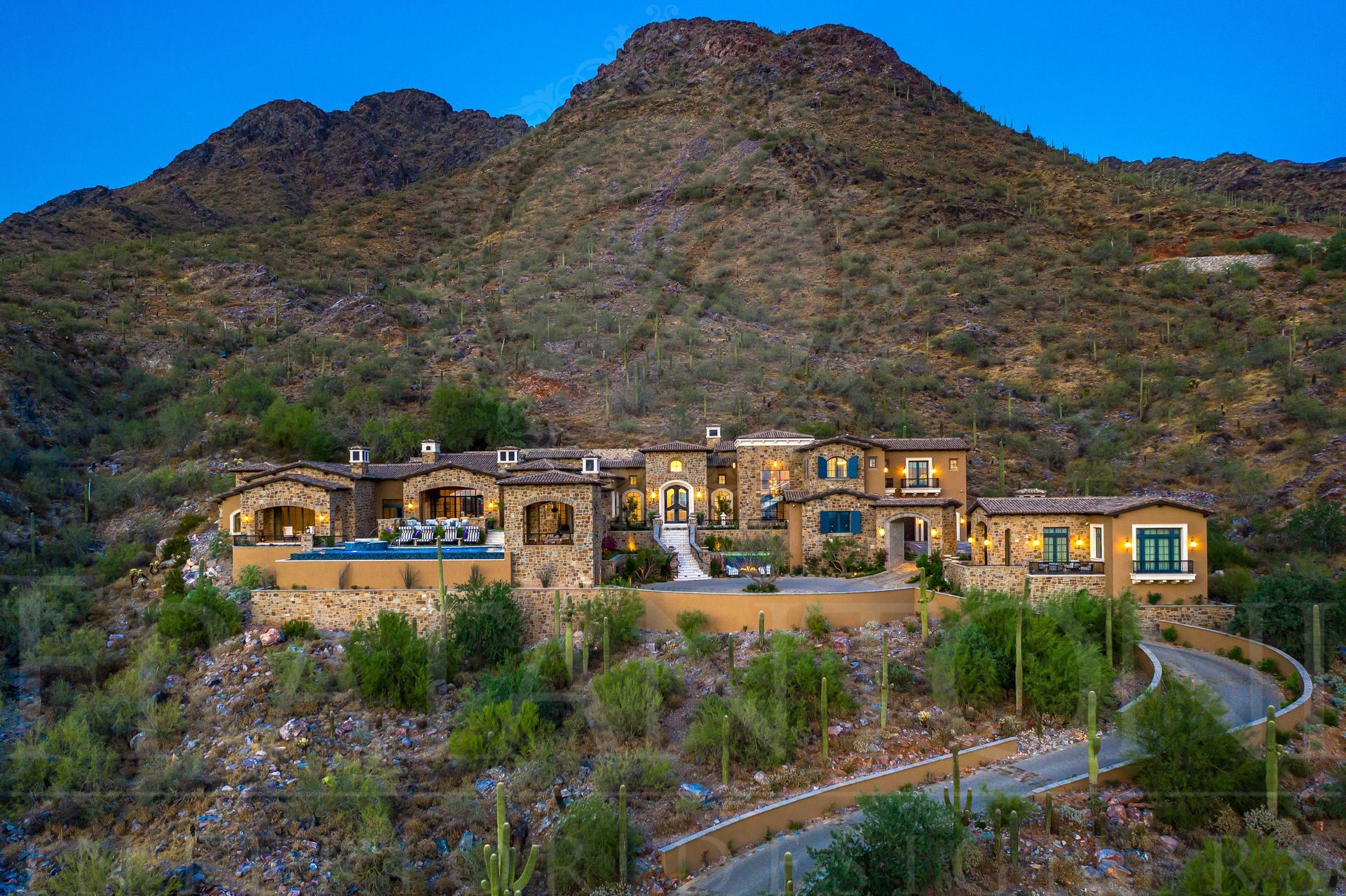 French style home resting on an elevation, resting against a mountainside
