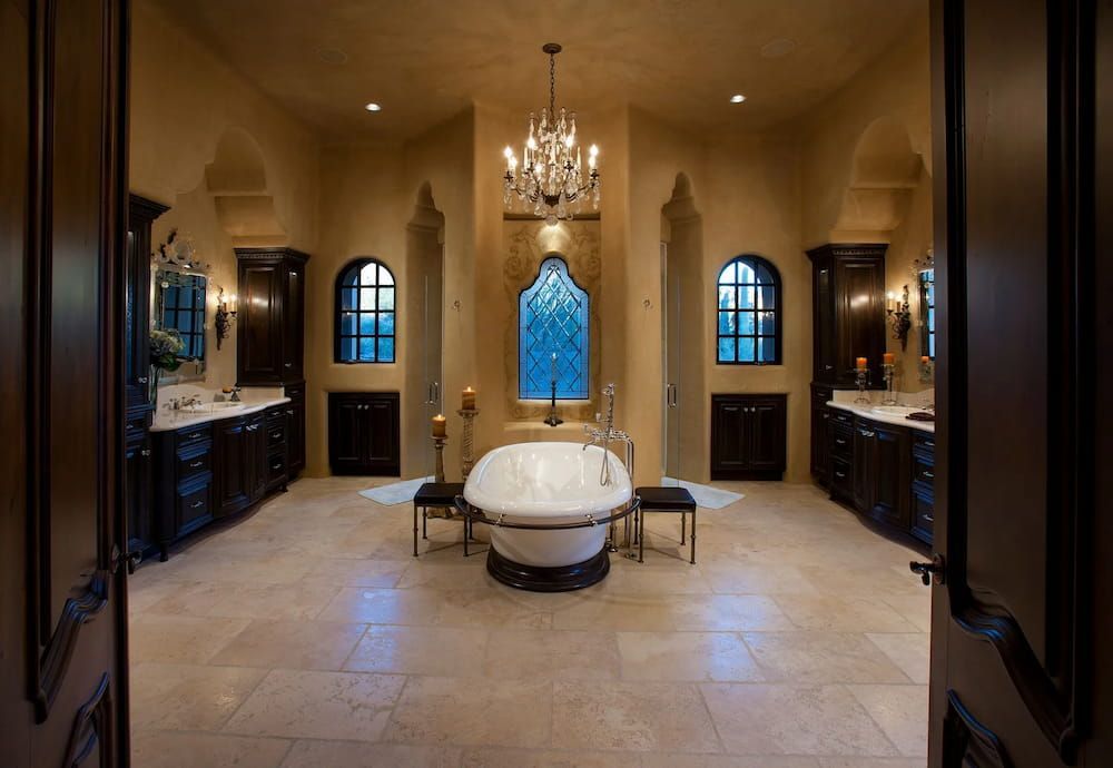 Luxurious bathroom with ornate dark wood cabinetry, a large tub, and a chandelier.