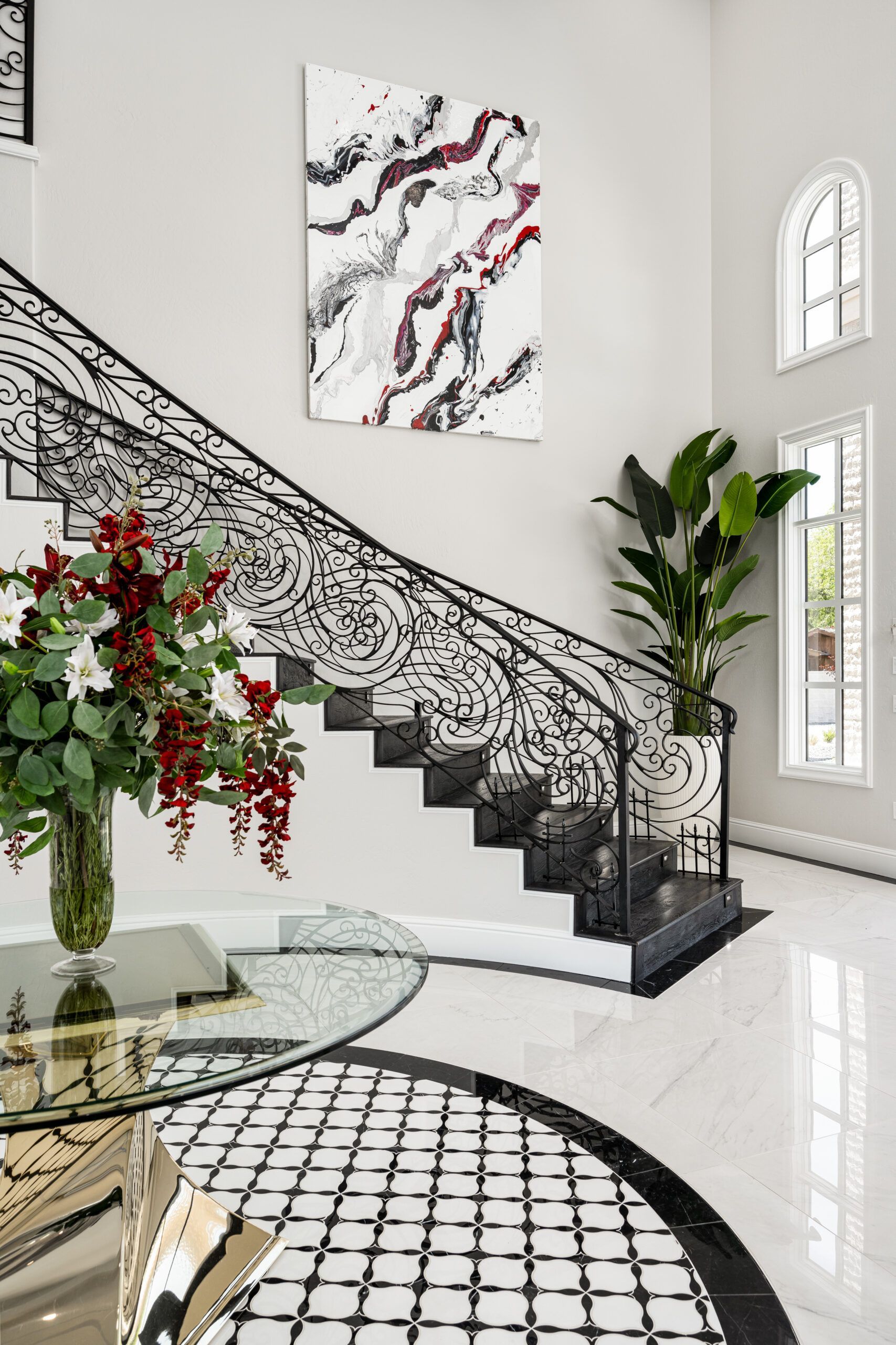 There is a staircase with a wrought iron railing in the middle of the room.