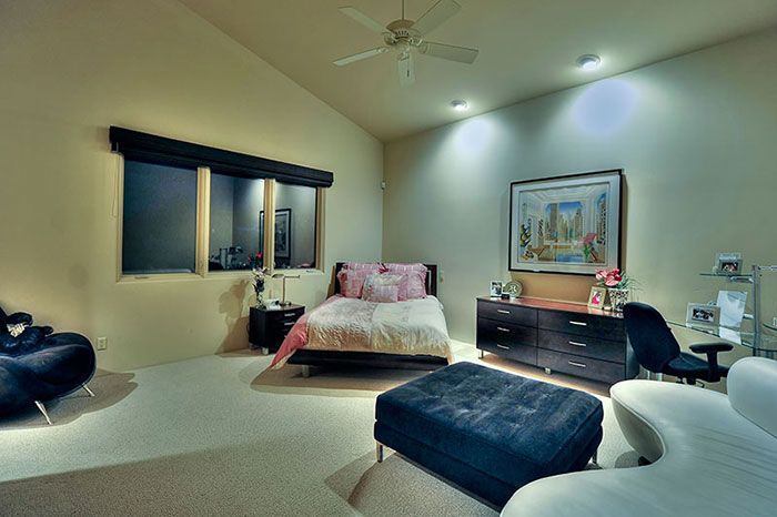 A bedroom with a large bed and a ceiling fan