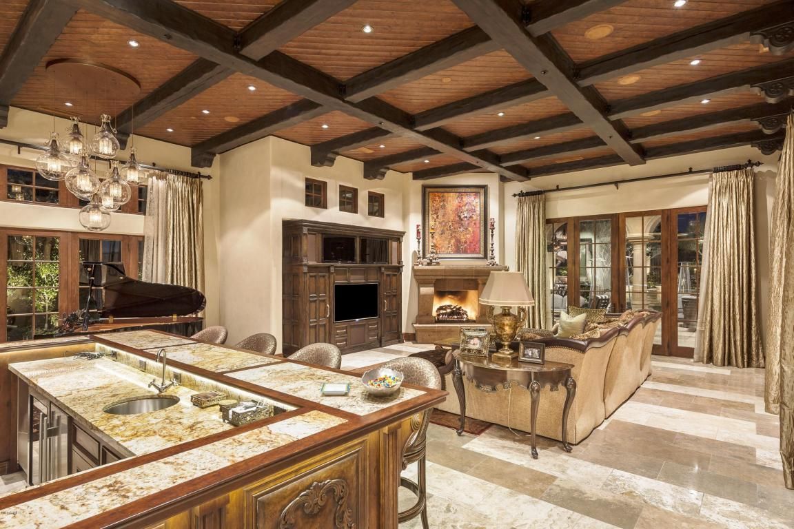 A large living room with a piano , couch , and fireplace.