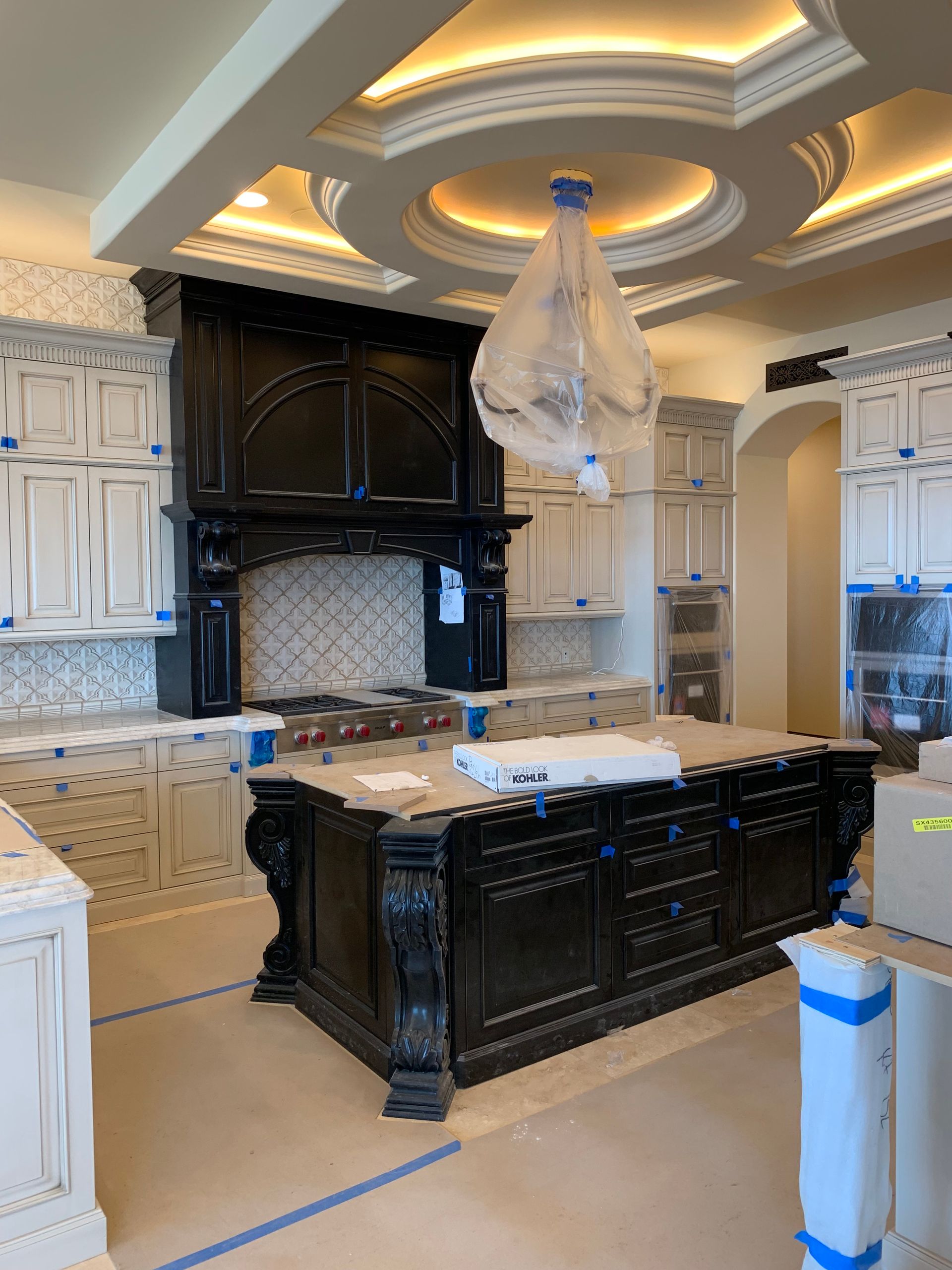 A kitchen under construction with a large island in the middle.