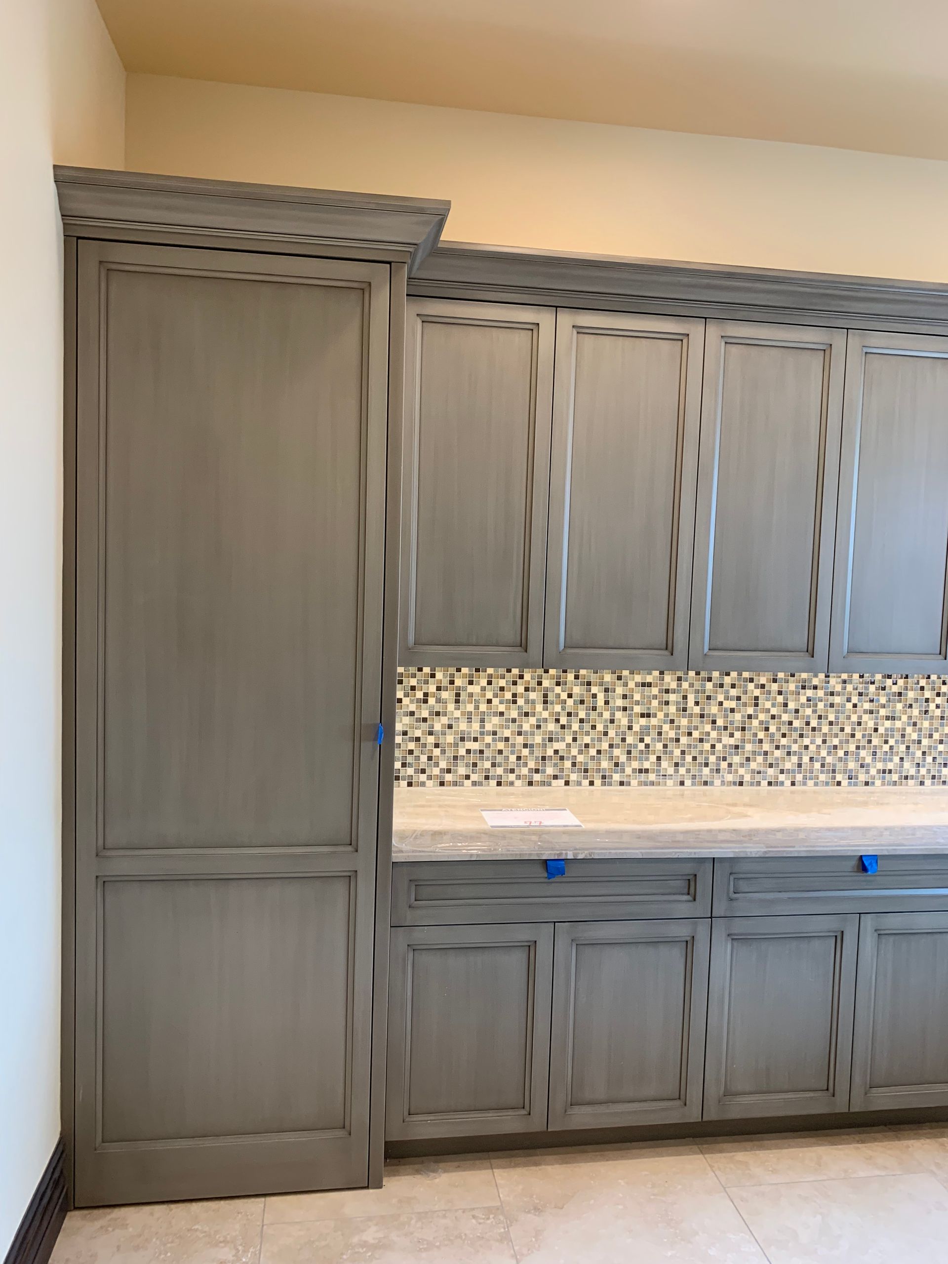 A kitchen with gray cabinets and a counter top.