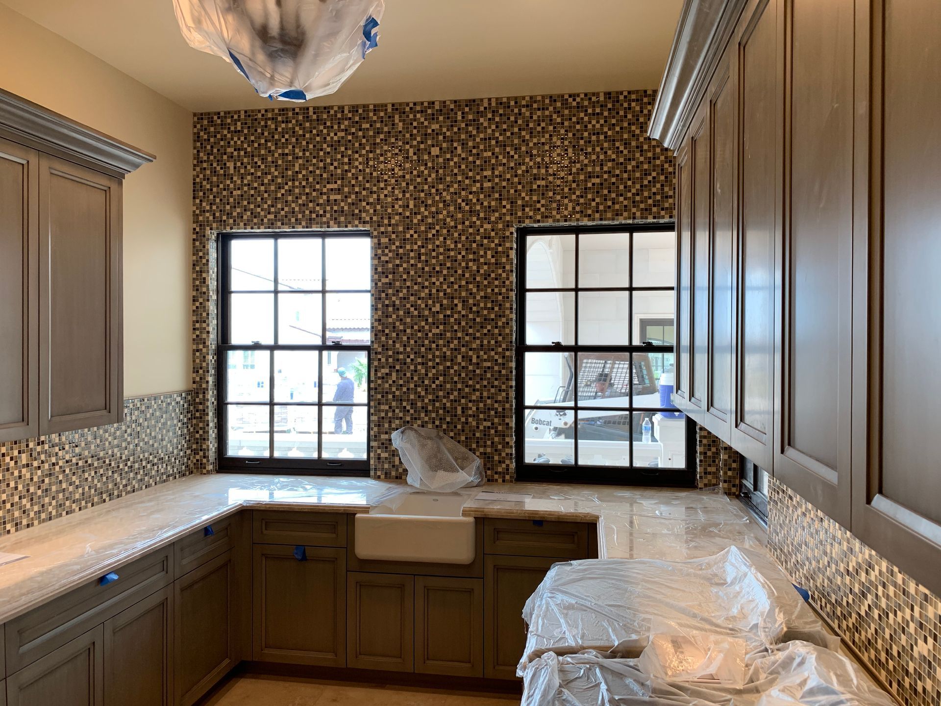 A kitchen with a sink , cabinets , and a window.