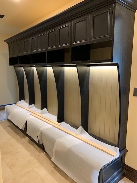 A row of black cabinets are lined up in a room