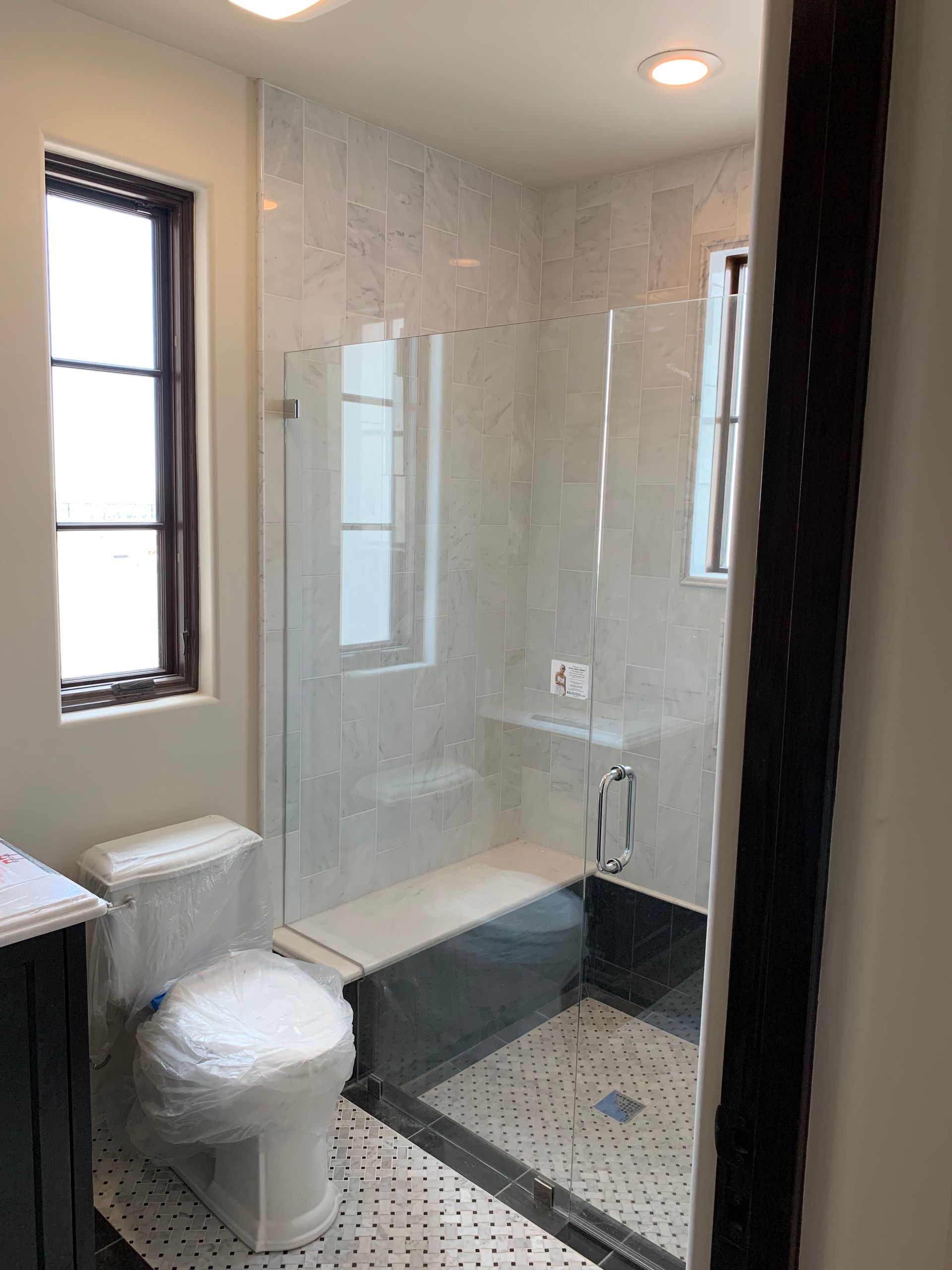 A bathroom with a toilet , tub , shower and window.
